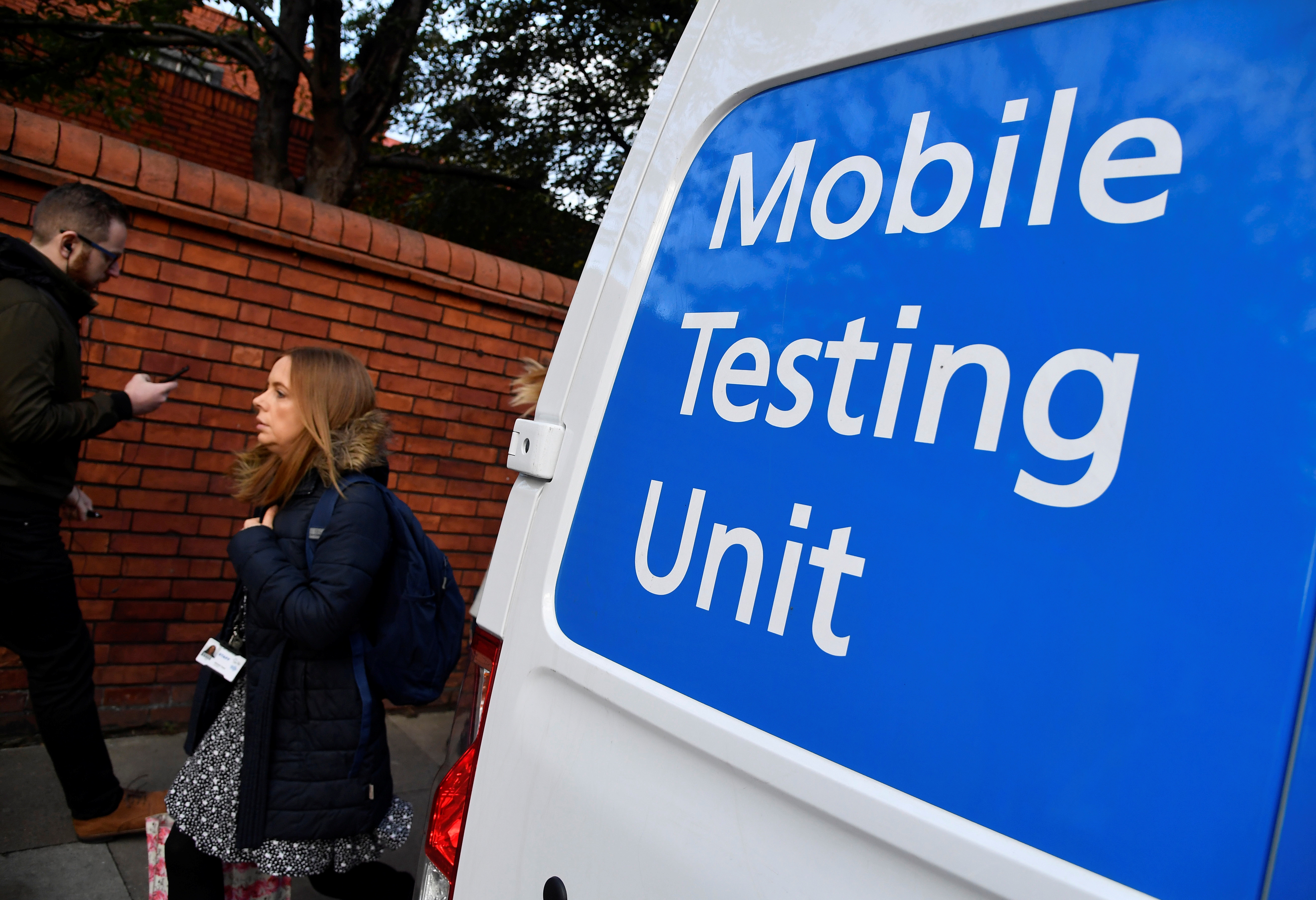 People walk past a COVID-19 Mobile Testing Unit van, amidst the spread of the coronavirus disease (COVID-19), in London