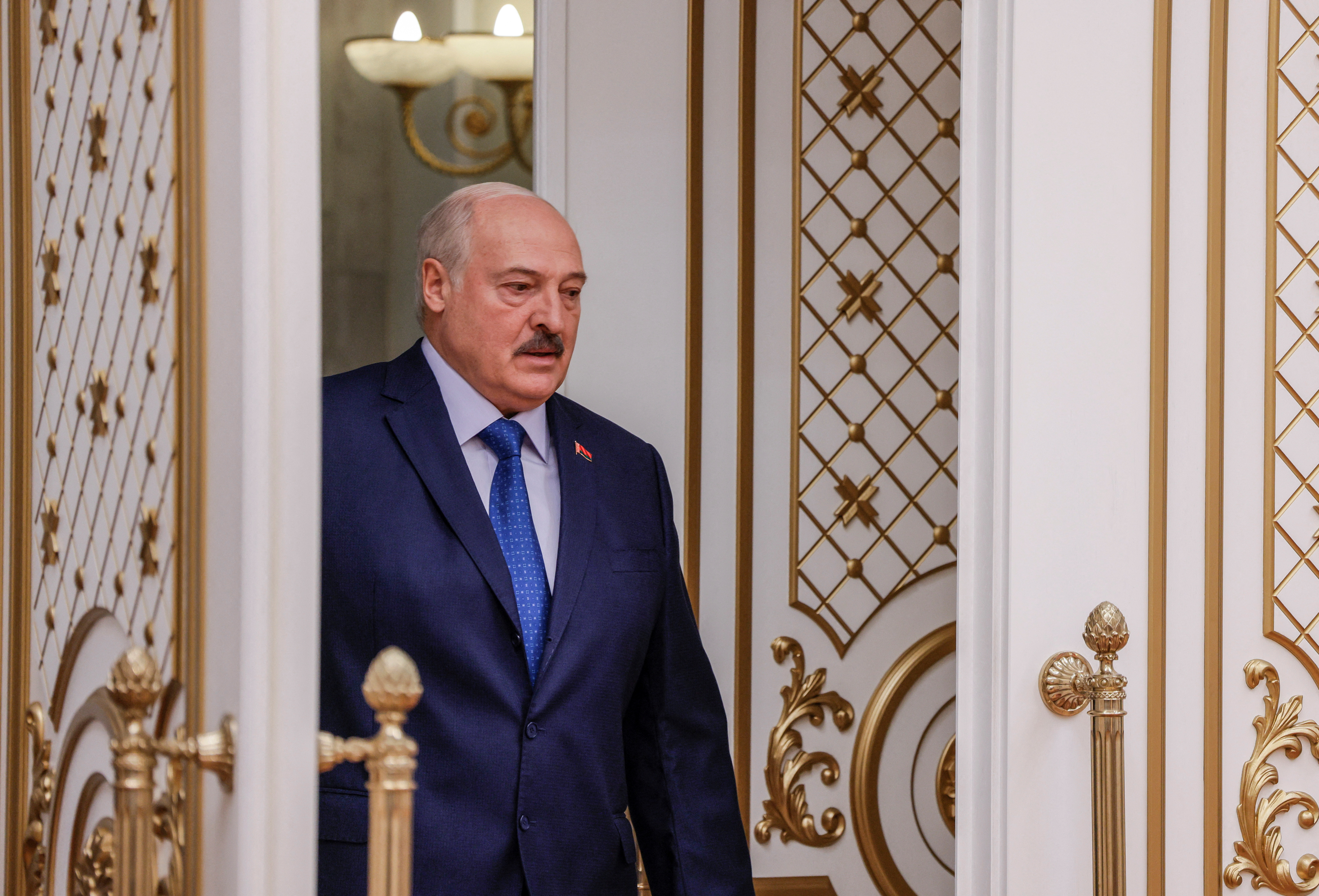 Belarusian President Alexander Lukashenko walks before a press conference in Minsk
