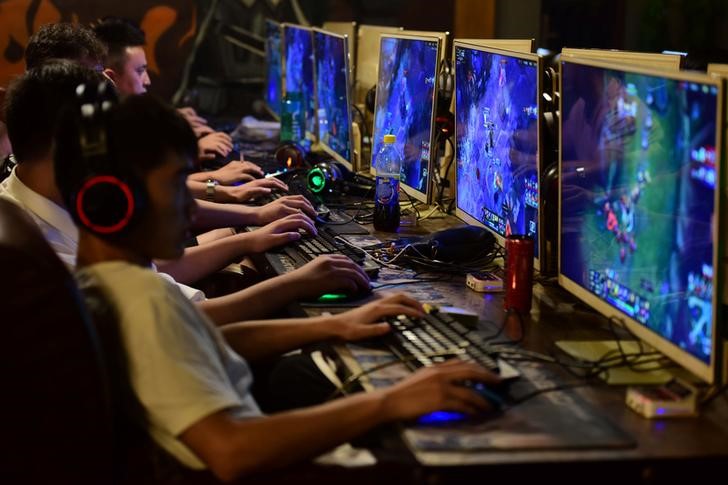 People play online games at an internet cafe in Fuyang