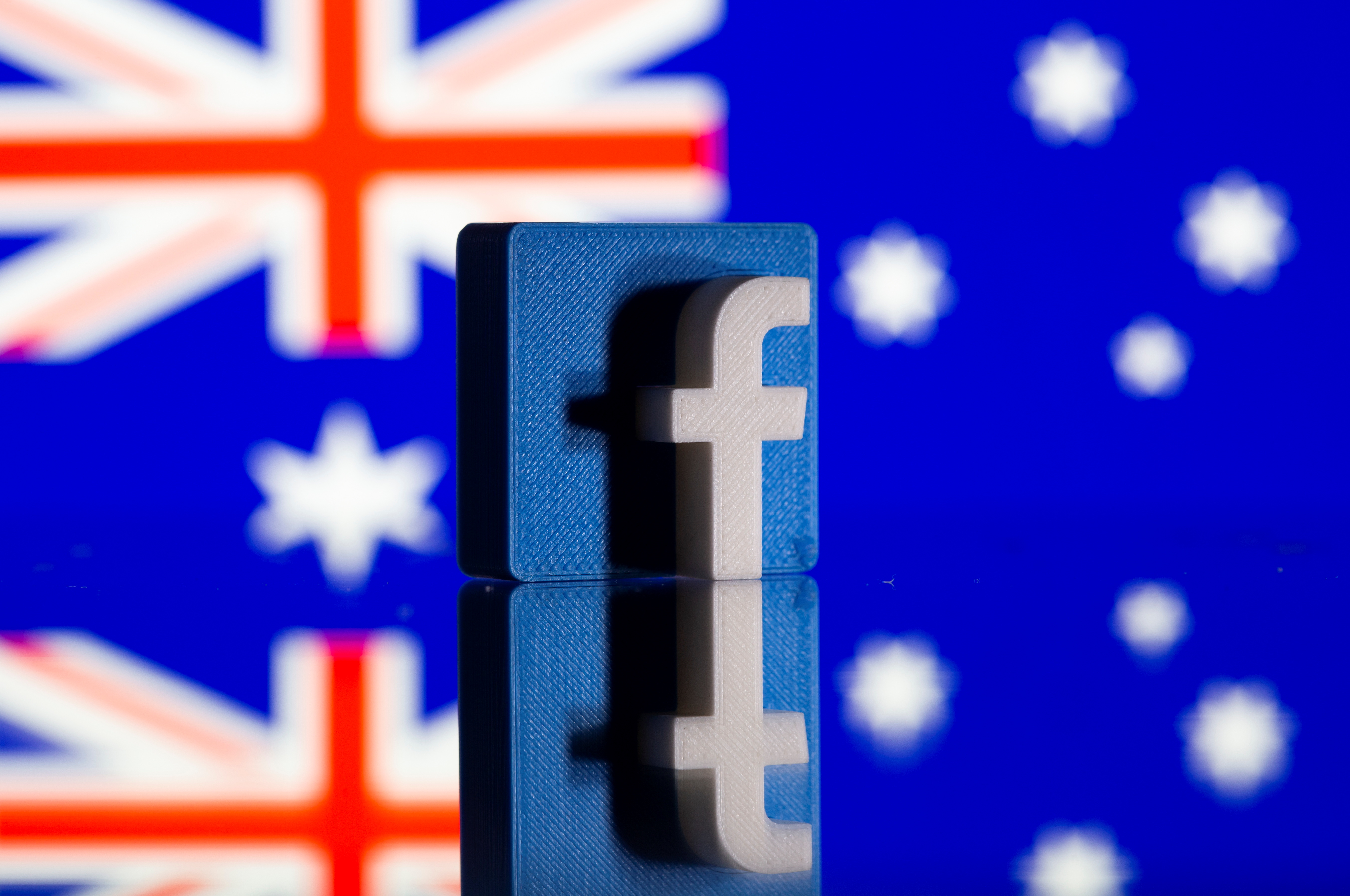 A 3D printed Facebook logo is seen in front of displayed Australia's flag in this illustration photo