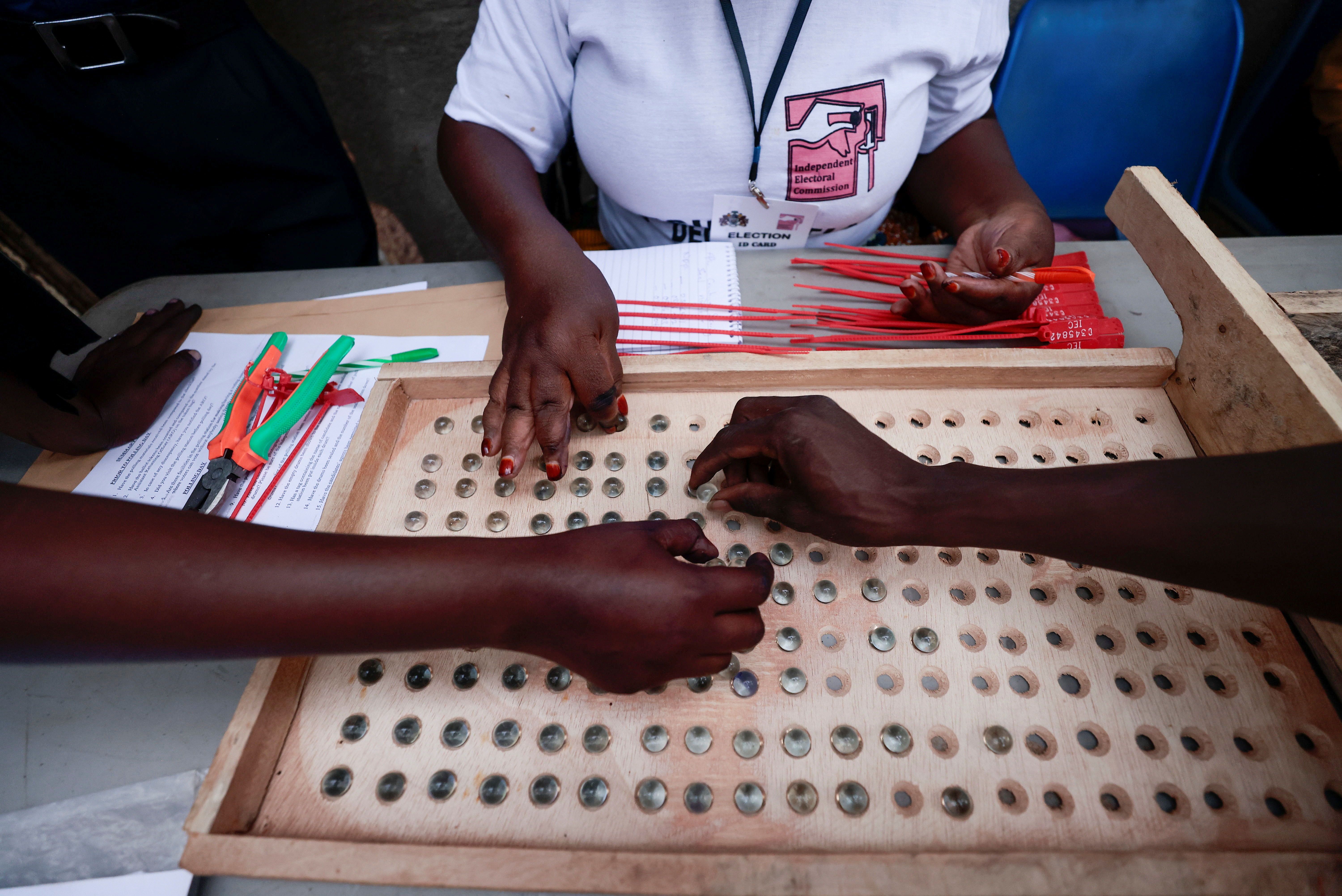 Gambian's polling station staff members count marbles that represent votes during the presidential election, in Banjul, Gambia December 4, 2021. REUTERS/Zohra Bensemra