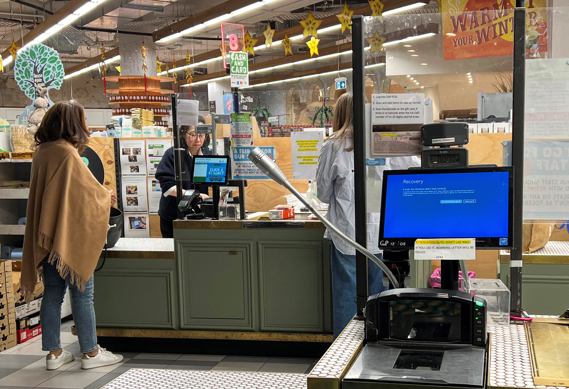 A cash register shows a blue screen at a grocery store affected by a cyber outage in Sydney