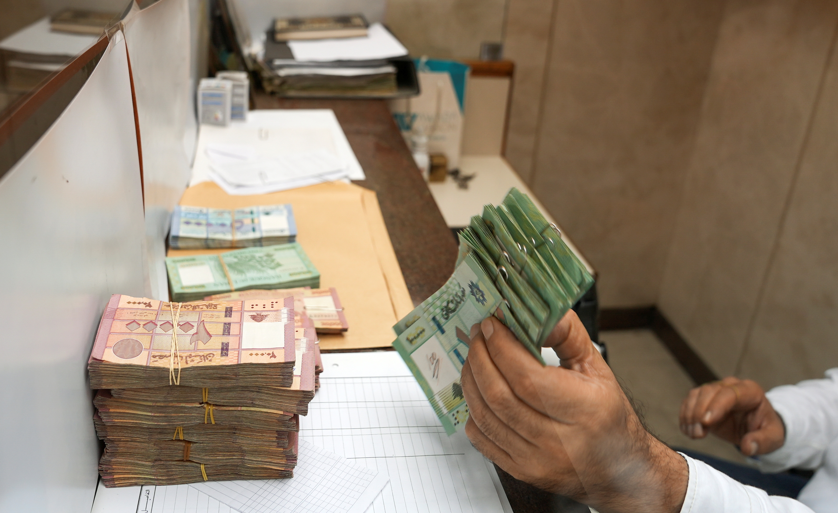 A man holds up Lebanese pound banknotes in Beirut