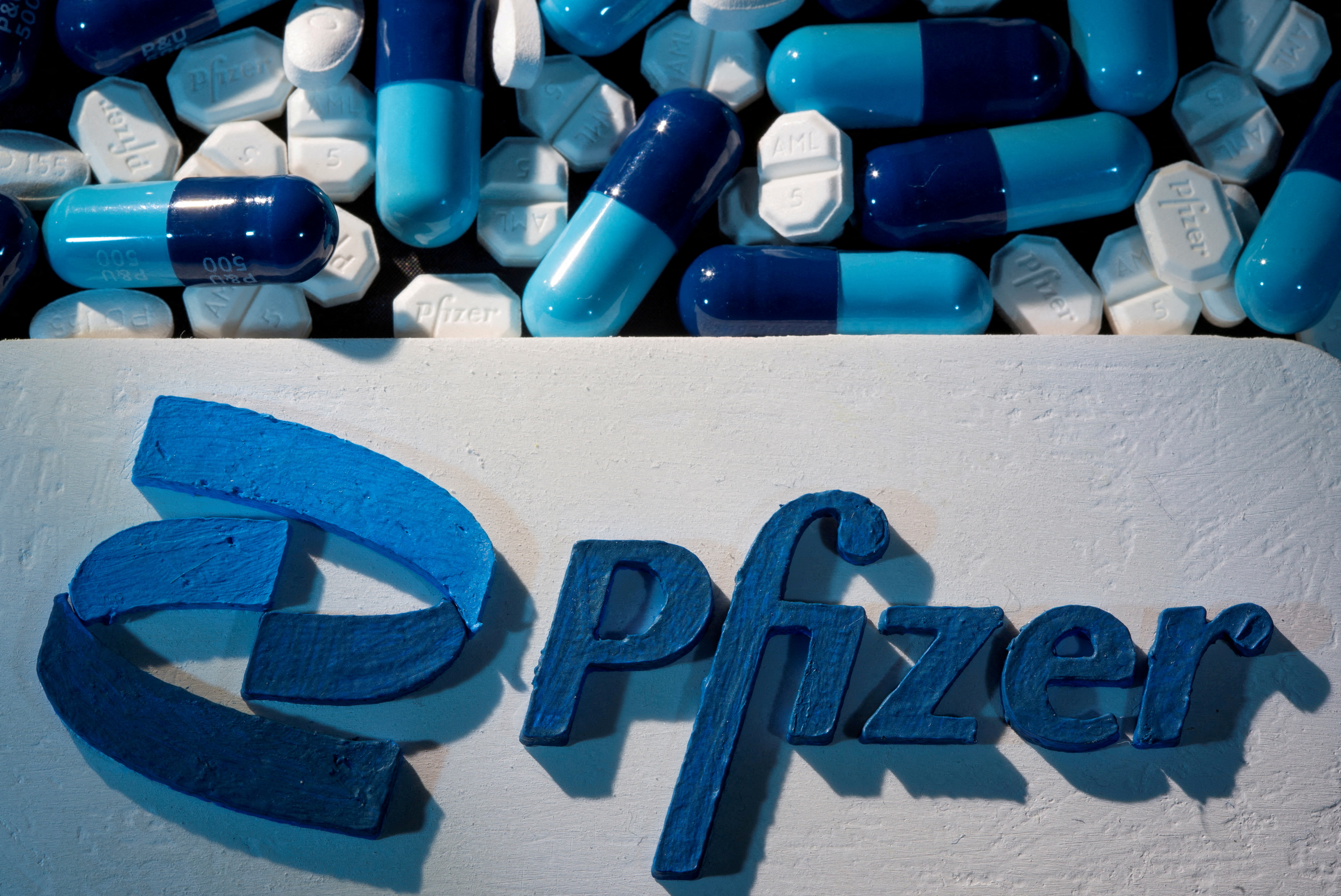 3D printed Pfizer logo is placed near medicines from the same manufacturer in this illustration