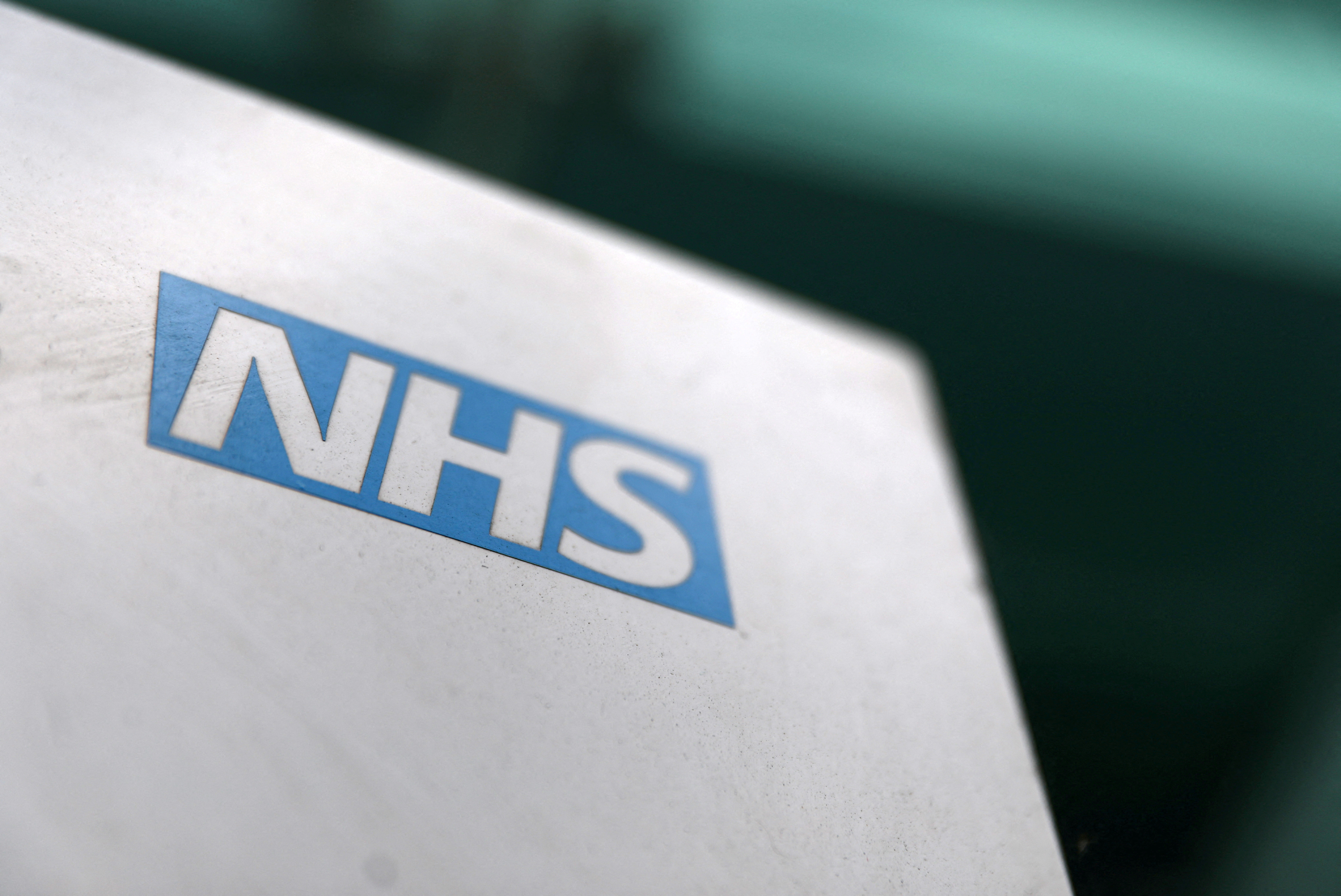 An NHS logo is displayed outside a hospital in London