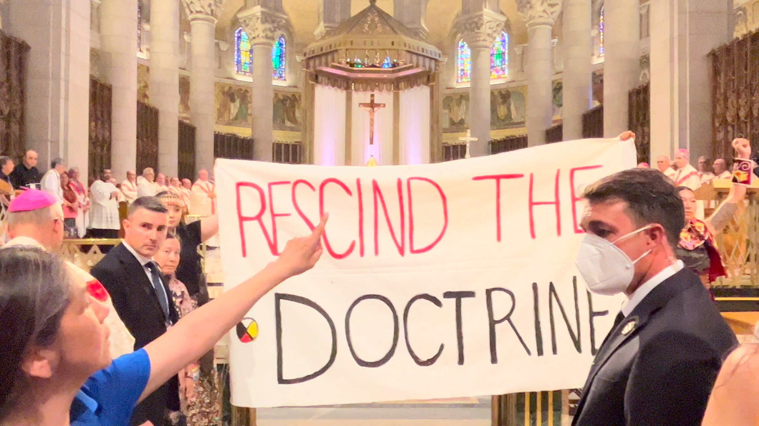 Indigenous people hold a banner against the discovery doctrine during a Mass presided over by Pope Francis at the Shrine of Sainte-Anne-de-Beaupre, Quebec