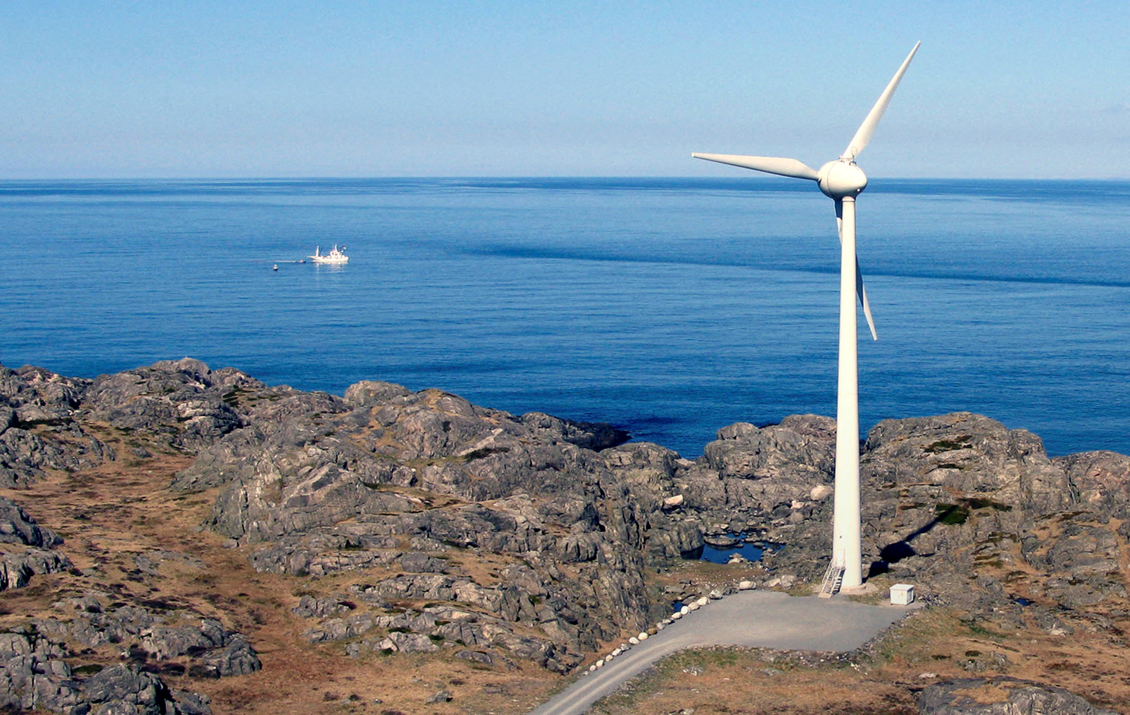 A windmill stands next to the ocean in Utsira, a North Sea island