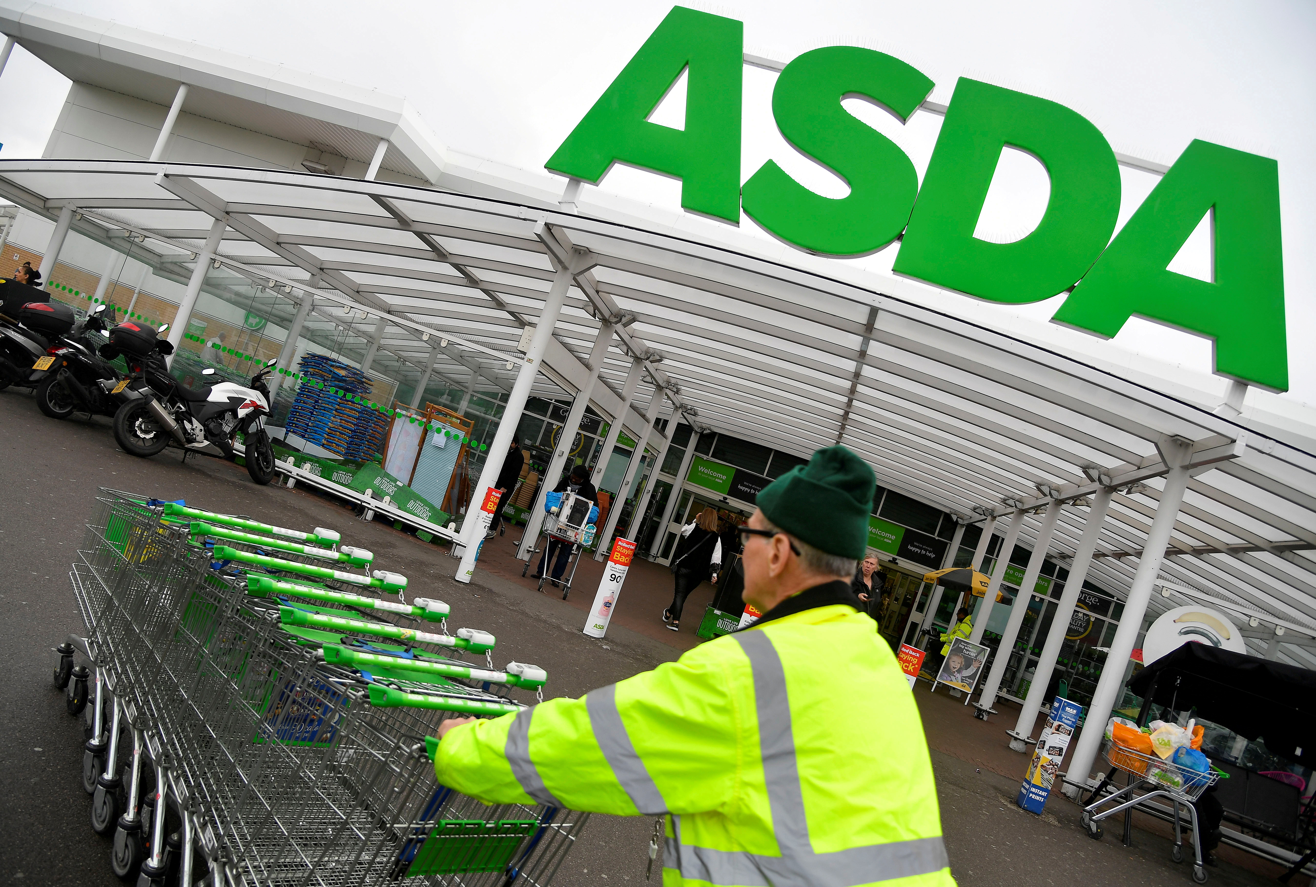 A worker pushes shopping trolleys at an Asda store in west London, Britain, April 28, 2018. REUTERS/Toby Melville