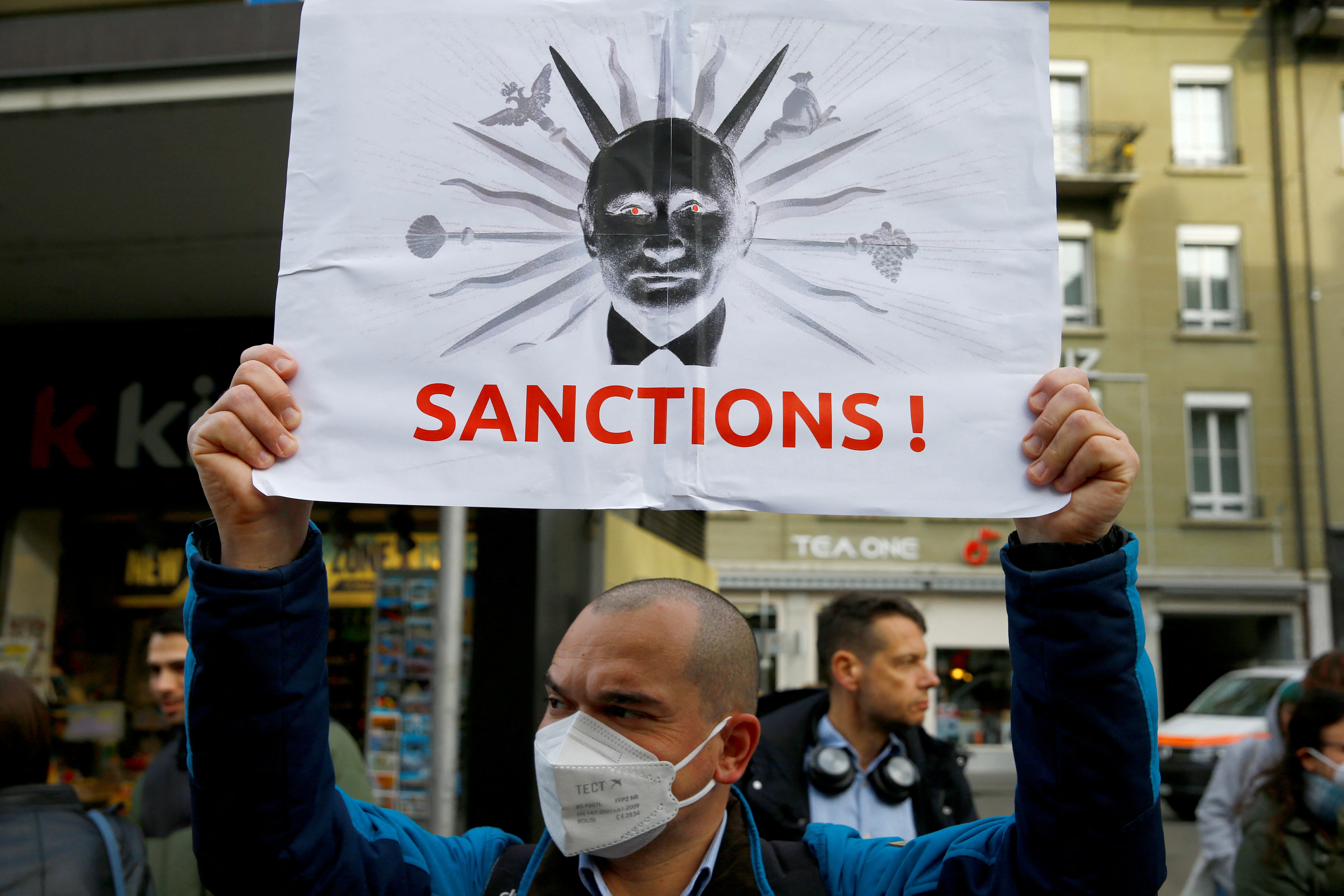 A man displays a poster during a protest by Ukranian people living in Switzerland
