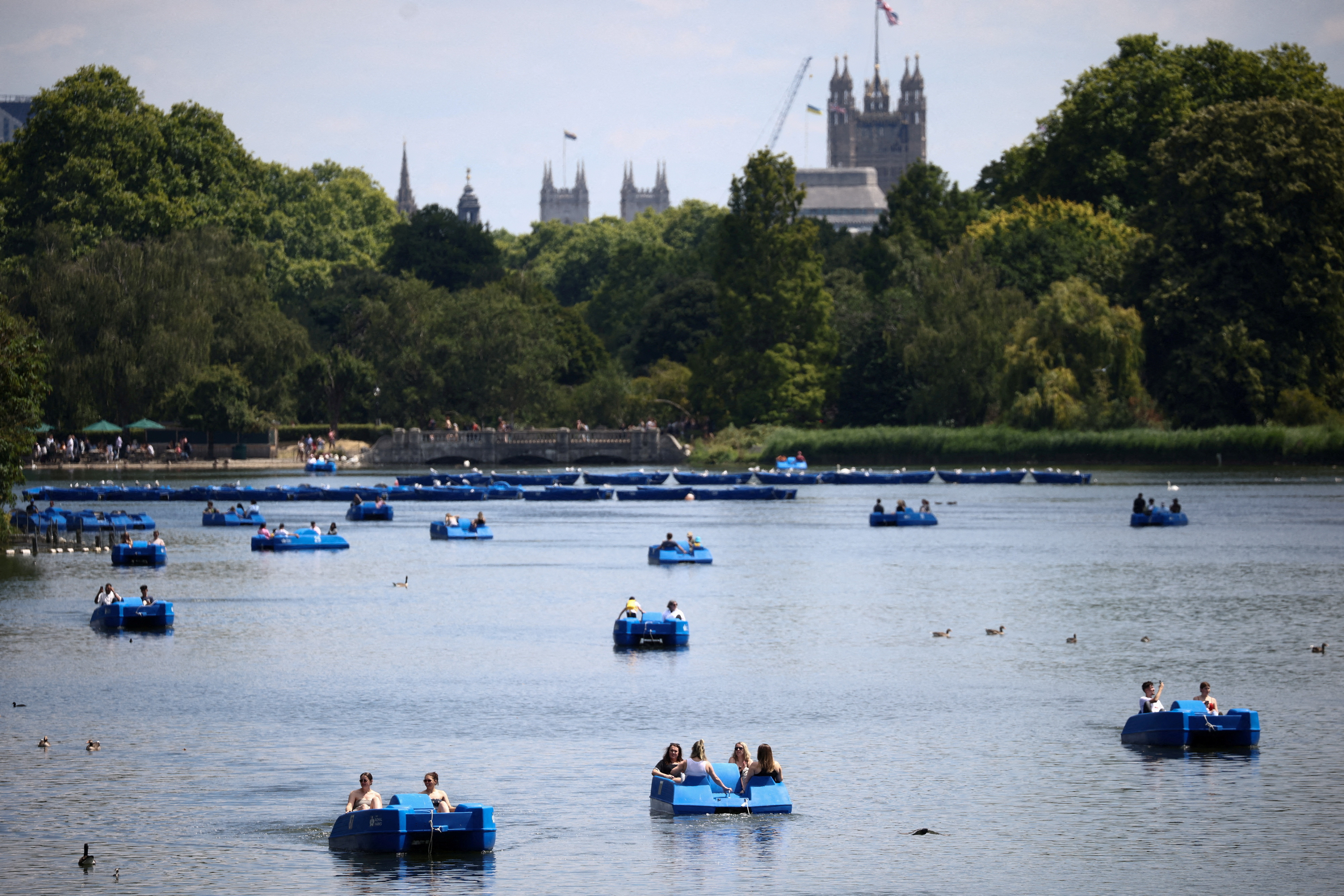 People ride pedal boats on the Serpentine Lake in Hyde Park, during warm weather in London