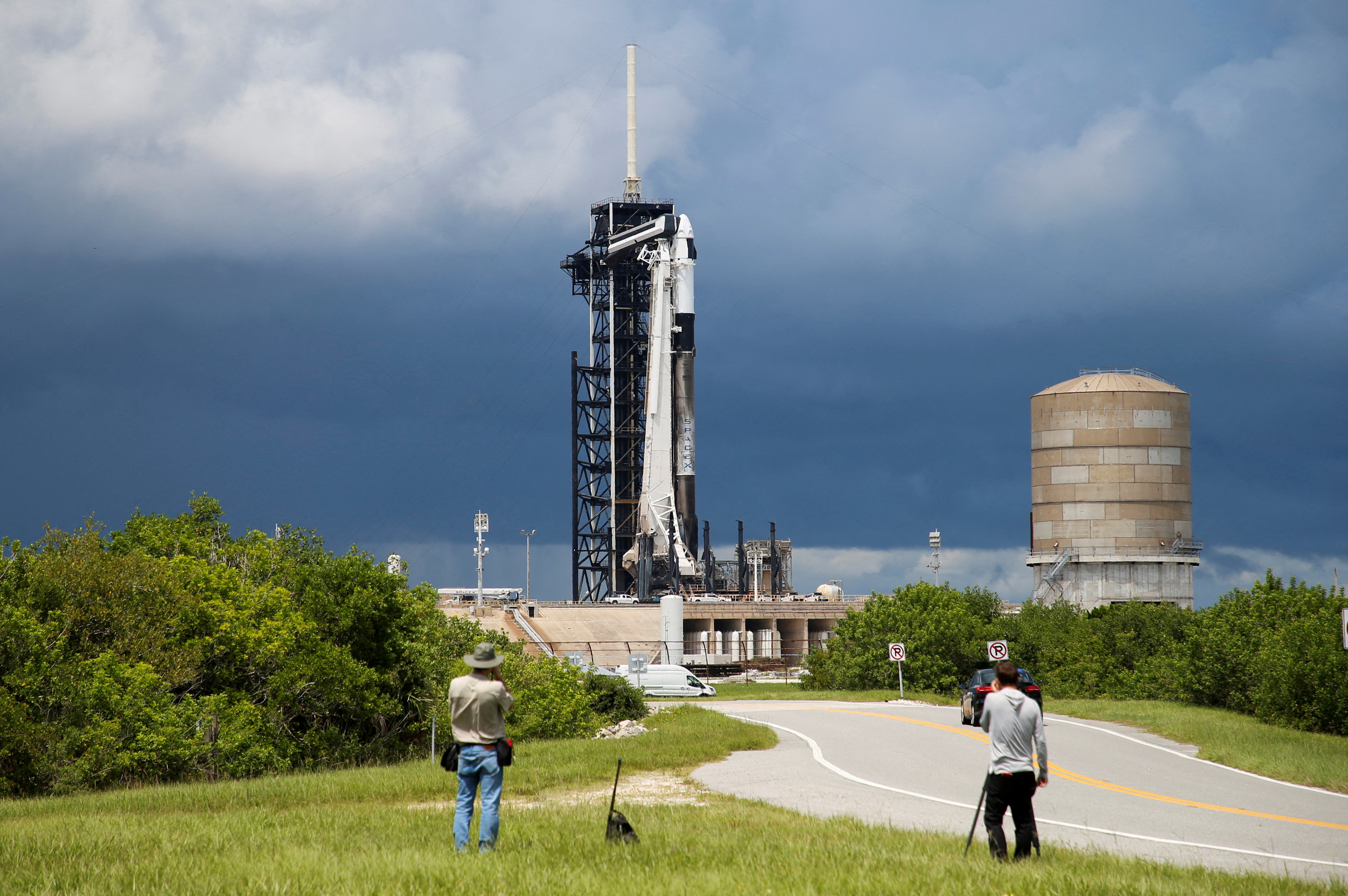 A SpaceX Falcon 9 rocket is prepared for launch of Polaris Dawn, a private human spaceflight mission, as photographers look on at the Kennedy Space Center in Cape Canaveral,