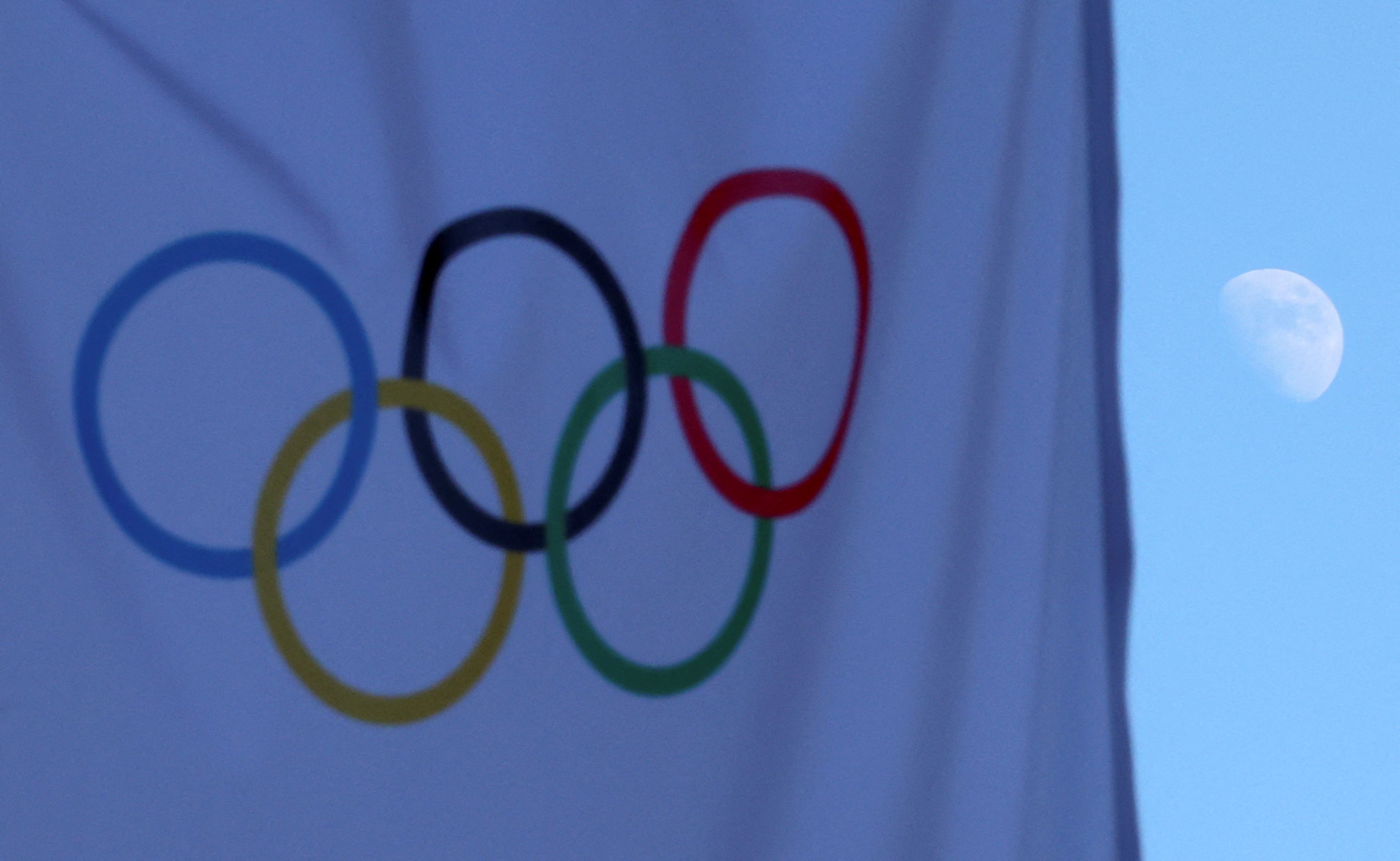The moon is pictured beside the Olympic flag ahead of the Beijing 2022 Winter Olympic Games in Beijing