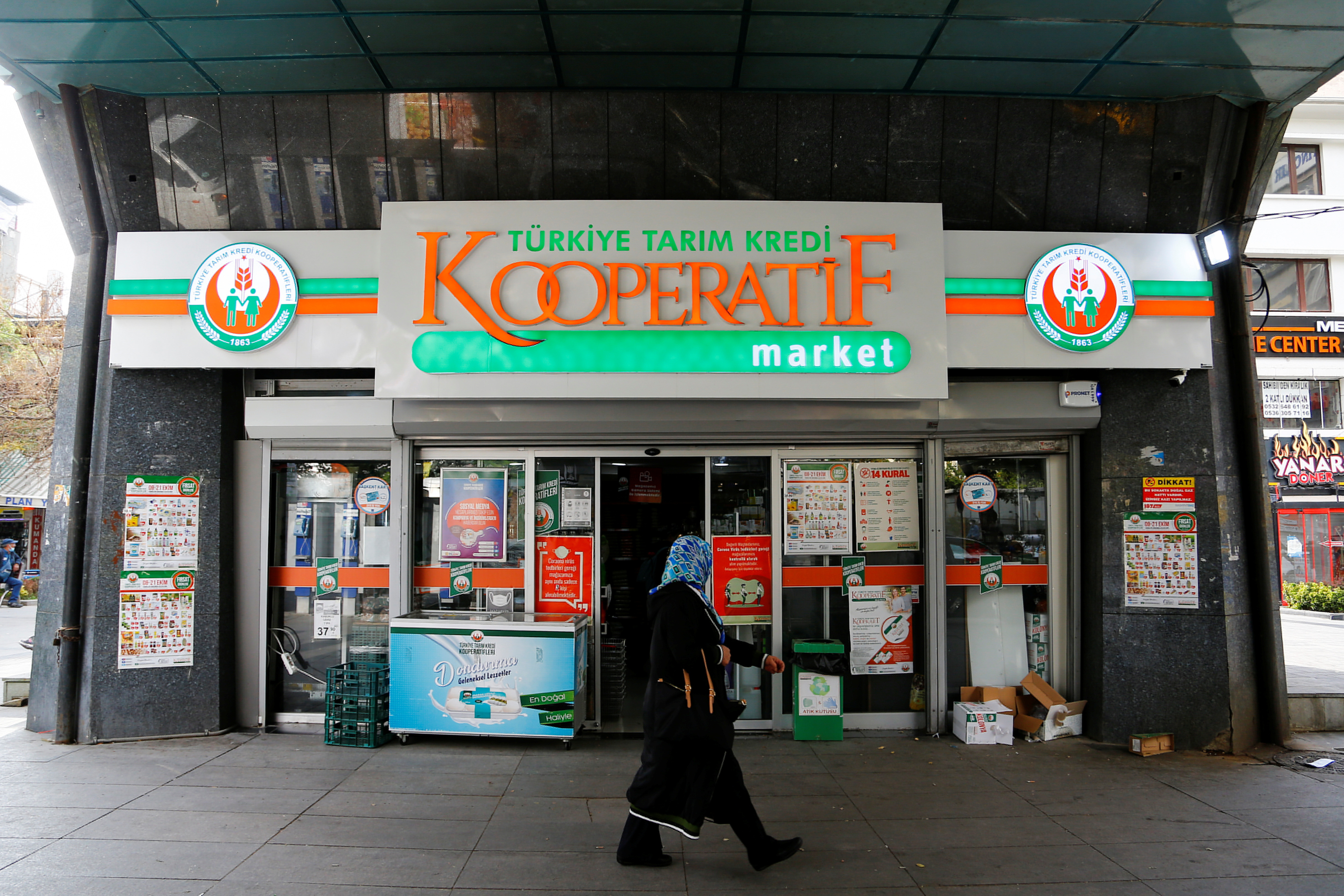 A woman walks past a grocery shop of the Agricultural Credit Cooperatives of Turkey in Ankara