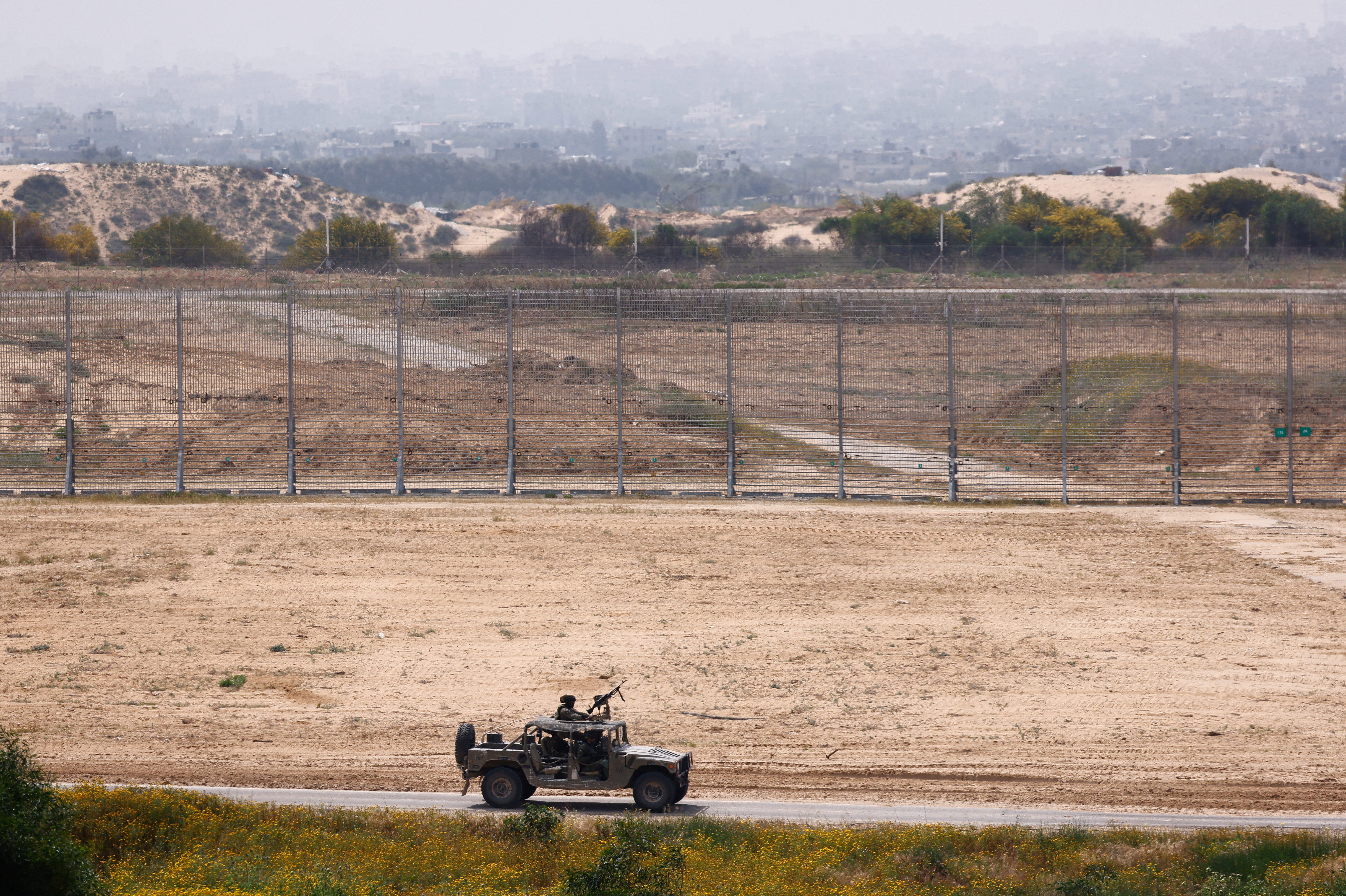 Israeli soldiers ride in a military jeep along the Israel-Gaza border