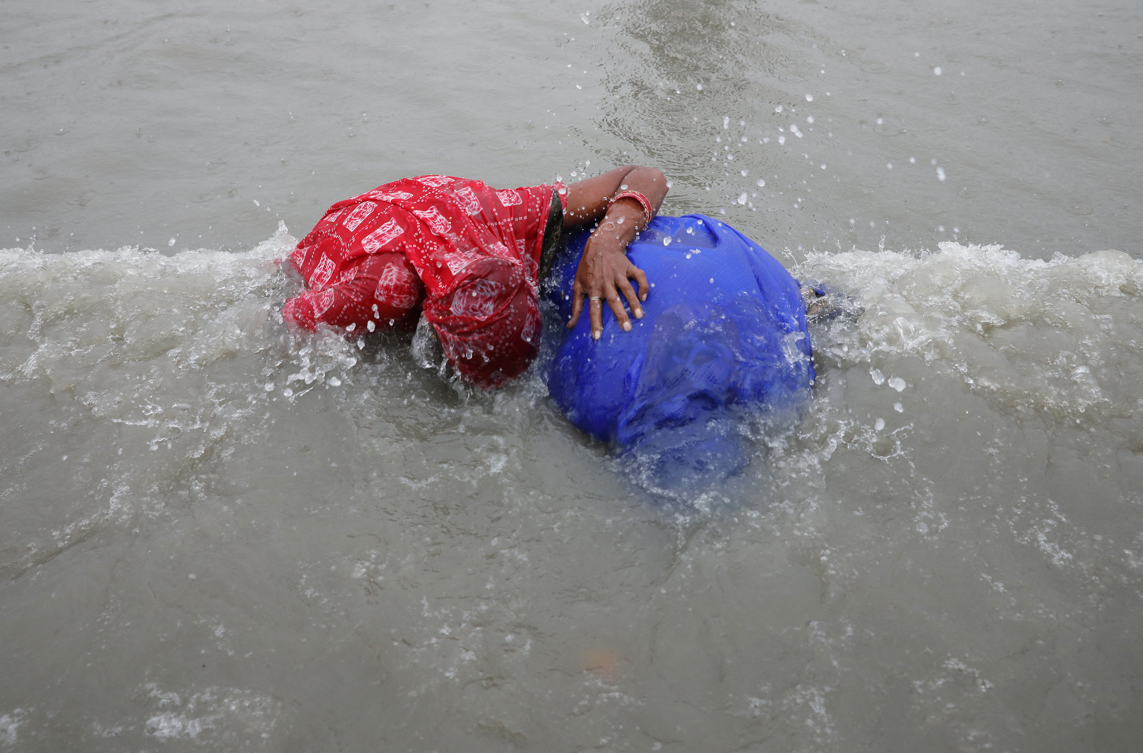 Hindu pilgrims take a dip as they gather at the confluence of the river Ganges and the Bay of Bengal on the occasion of 