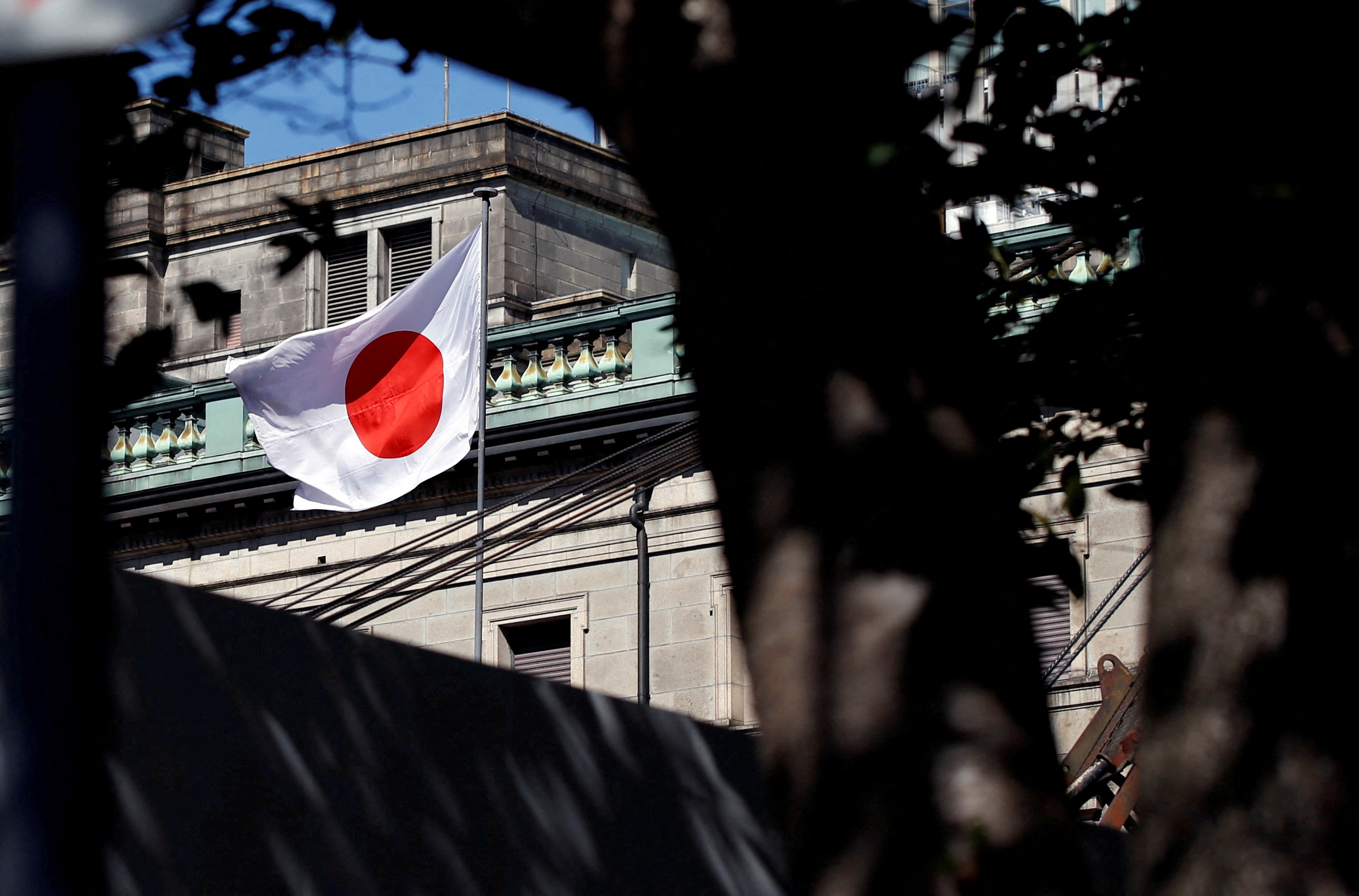 A Japanese flag flutters atop the Bank of Japan building under construction in Tokyo