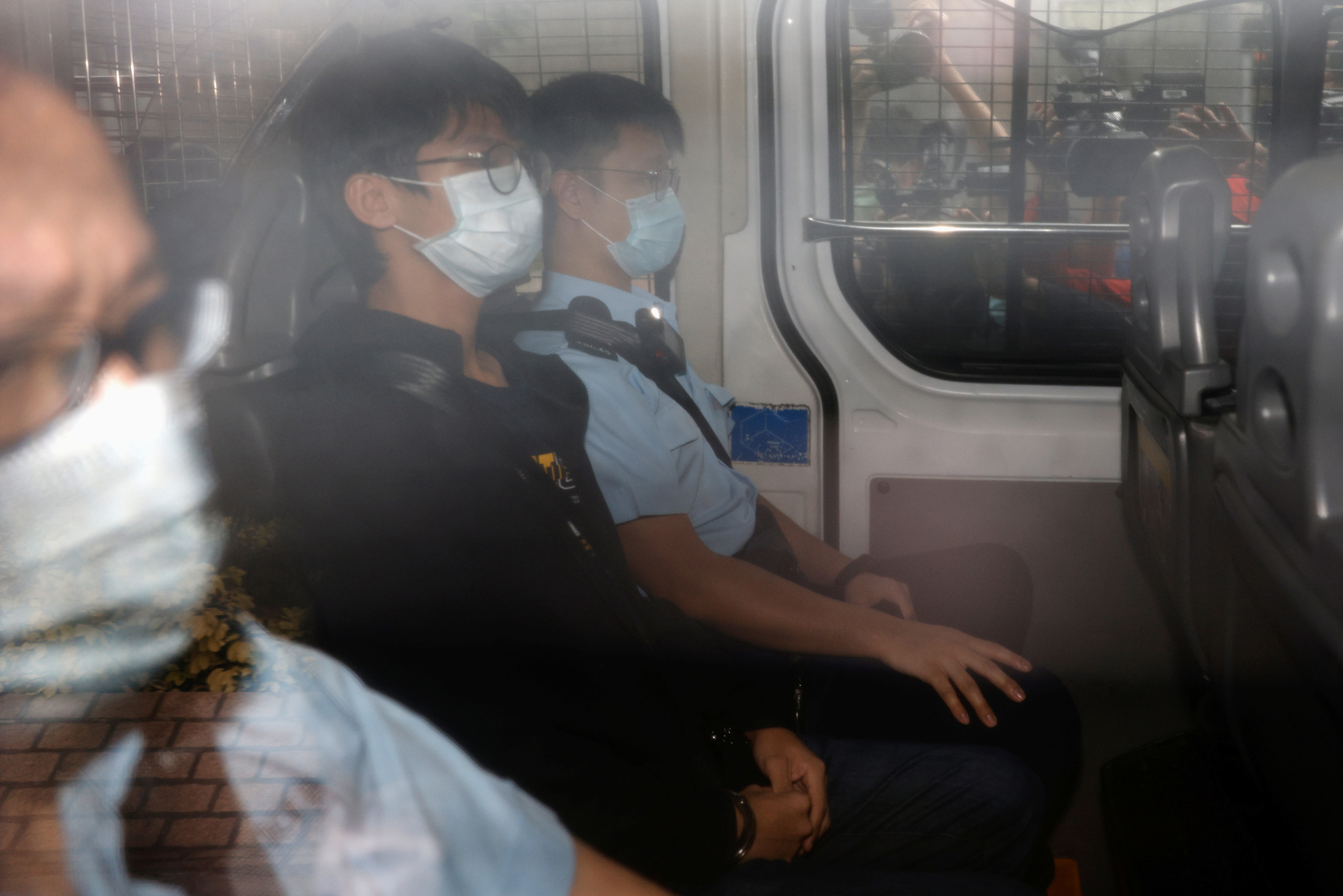Former convenor of pro-independence group Studentlocalism, Tony Chung Hon-lam arrives at West Kowloon Magistrates‘ Courts in a police van after he was arrested under the national security law, in Hong Kong, China October 15, 2020. REUTERS/Tyrone Siu