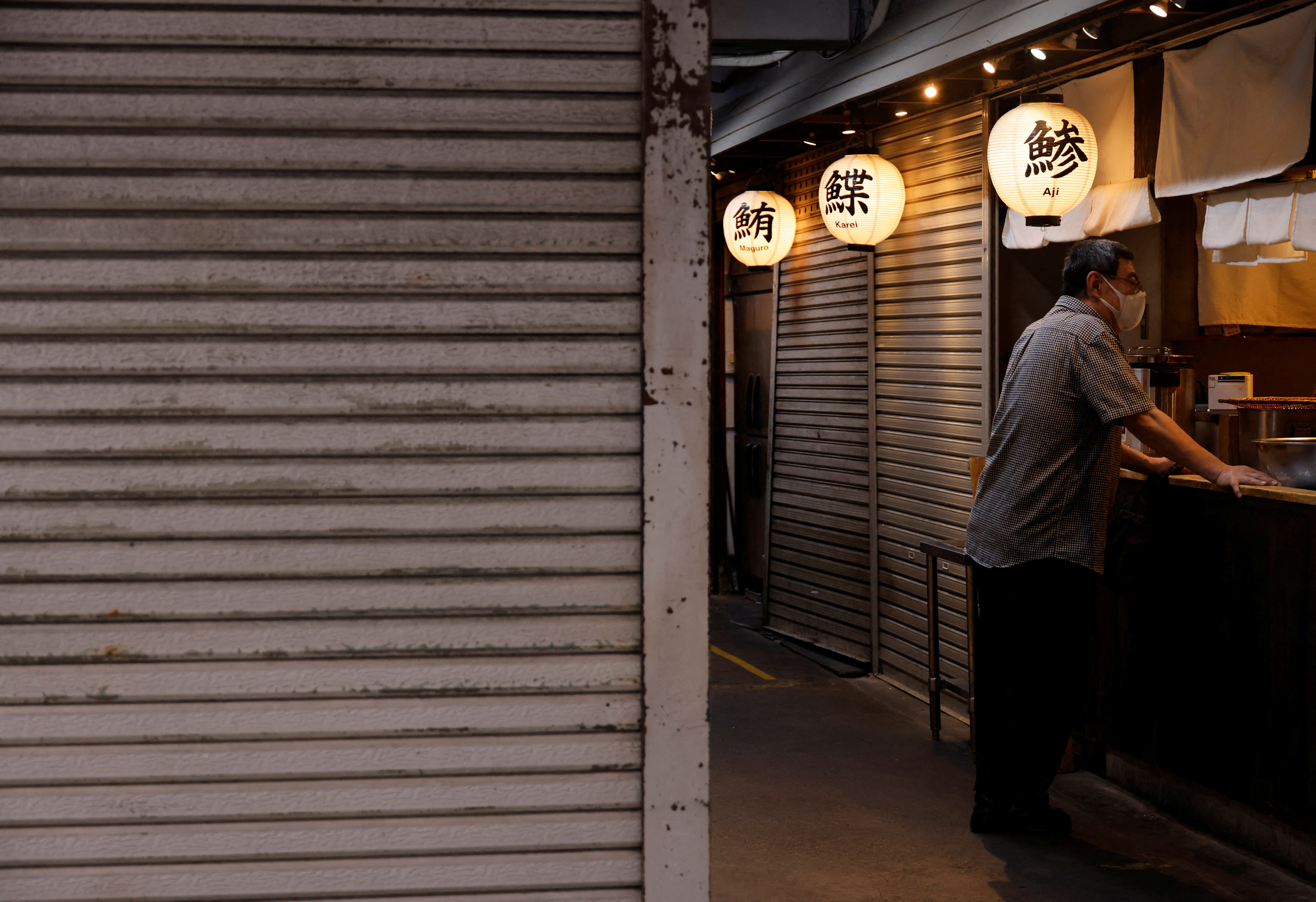 A man stands at a tempura restaurant at Tsukiji Outer Market in Tokyo, Japan