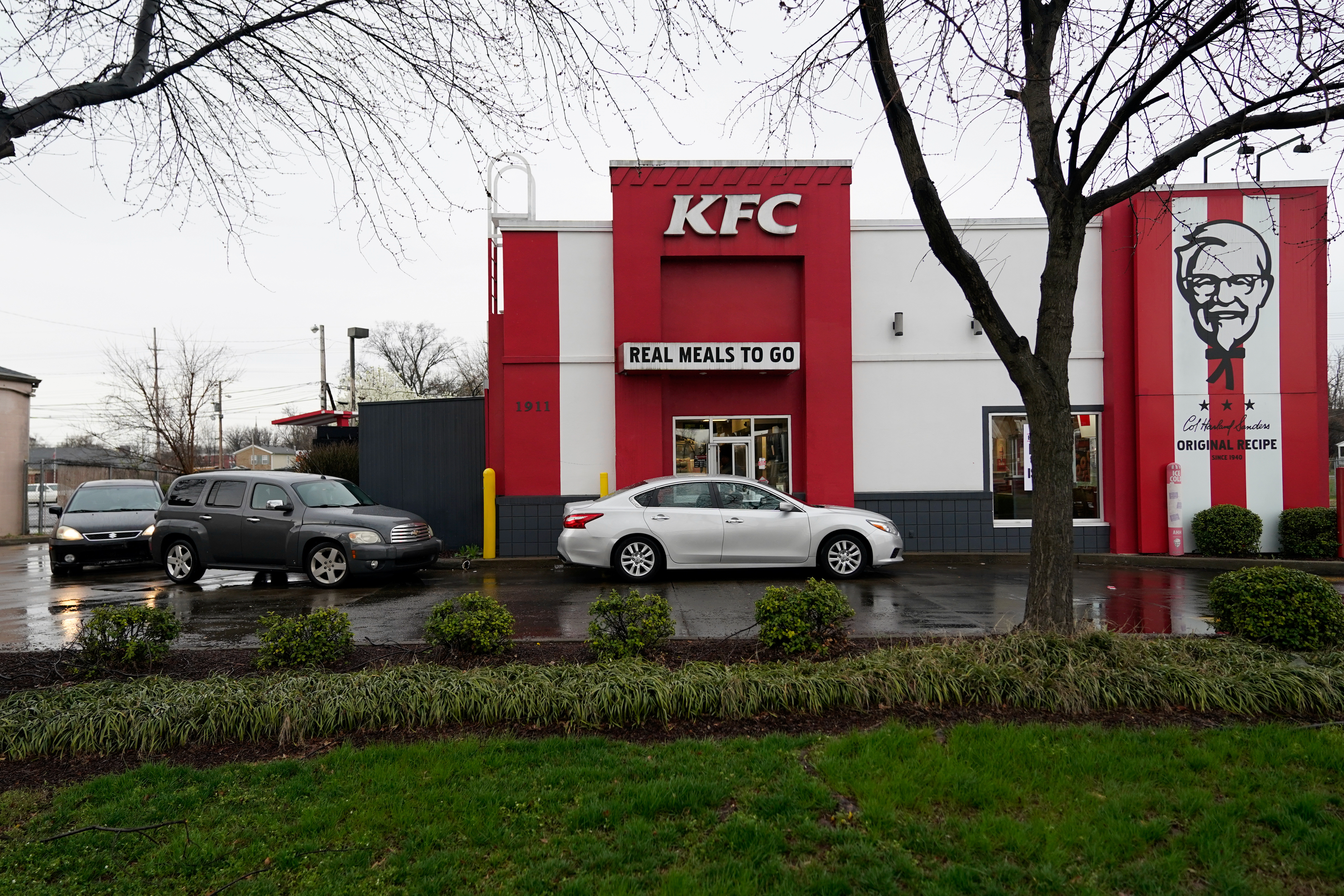 FILE PHOTO - Vehicles line up around Kentucky Fried Chicken after a state mandated carry-out only policy went into effect in order to slow the spread of the novel coronavirus (COVID-19) in Louisville