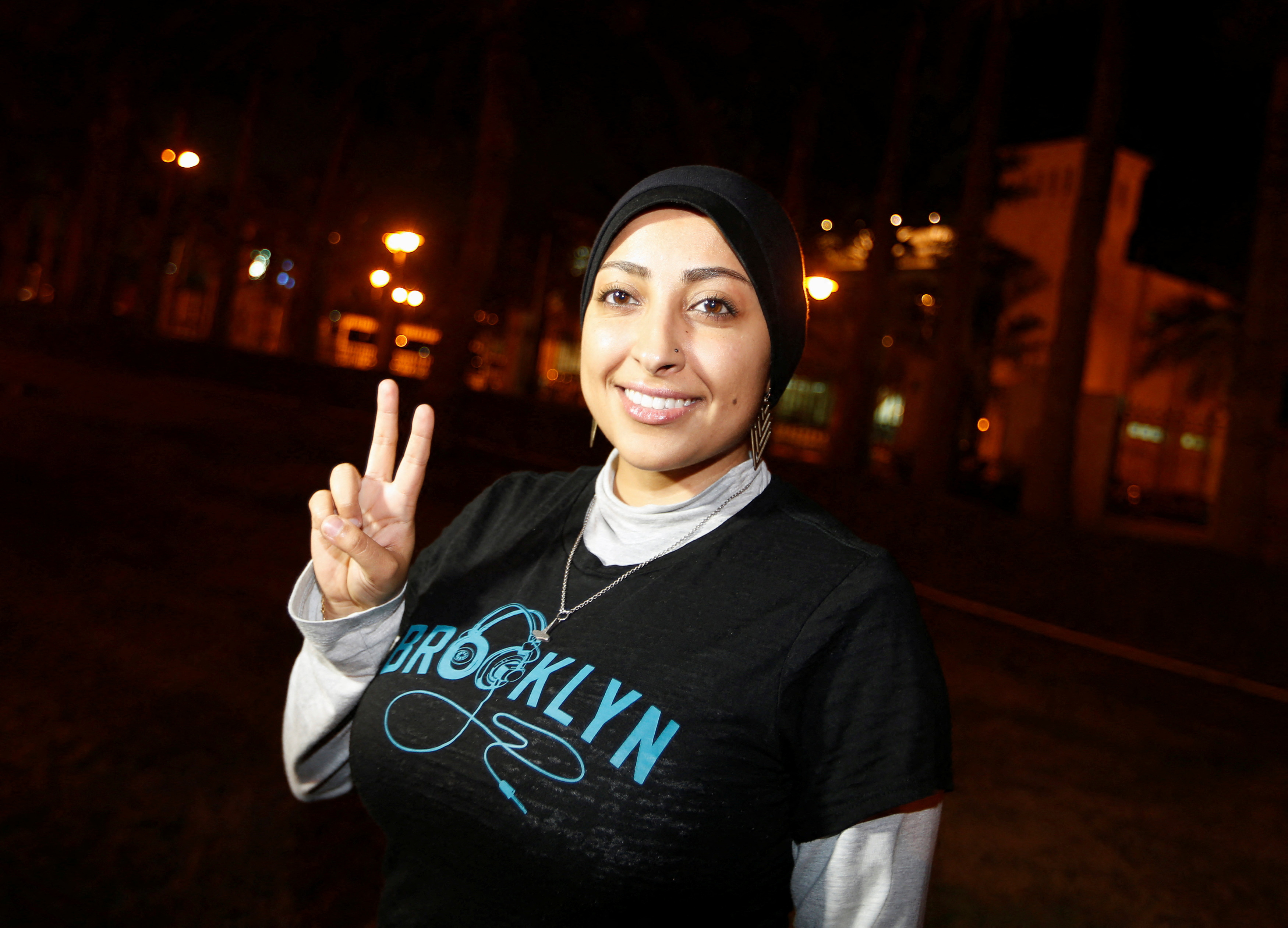 human rights activist Mariam Al-Khawaja flashed. "V" Signatures after being released outside the airport police station in Muharraq province