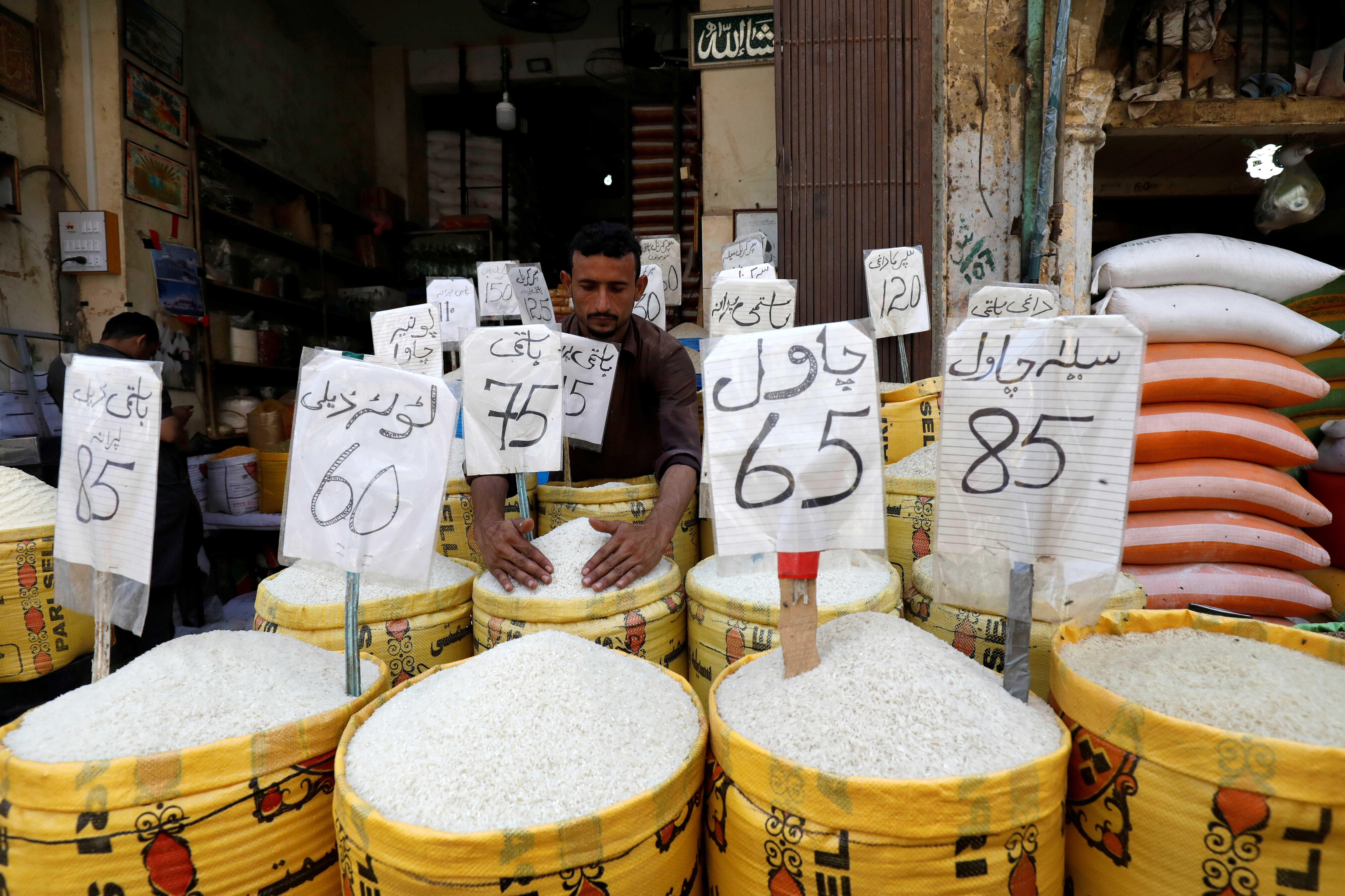 El proveedor organiza diferentes tipos de arroz en su tienda en un mercado mayorista en Karachi
