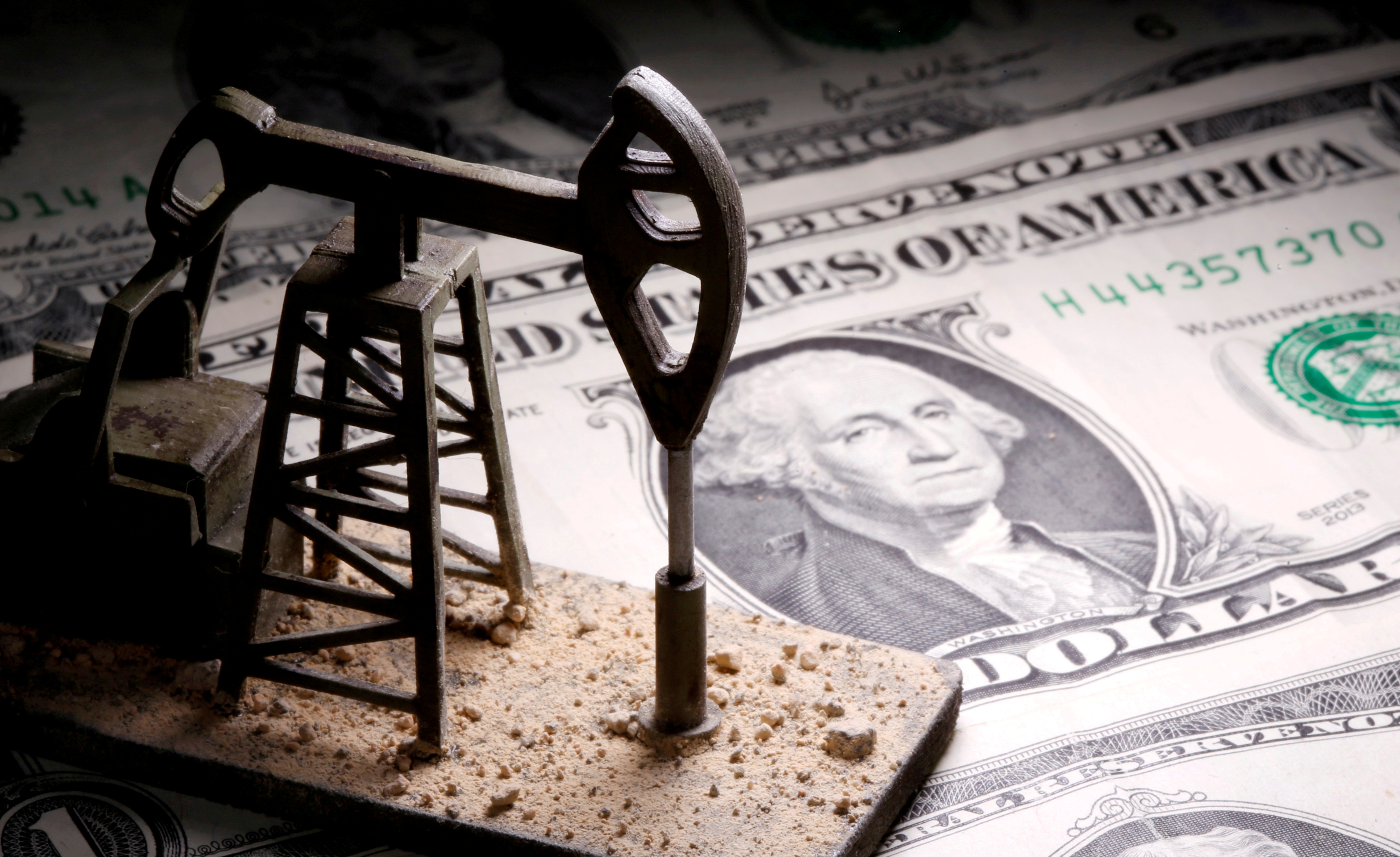FILE PHOTO: A 3D printed oil pump jack is placed on dollar banknotes in this illustration picture