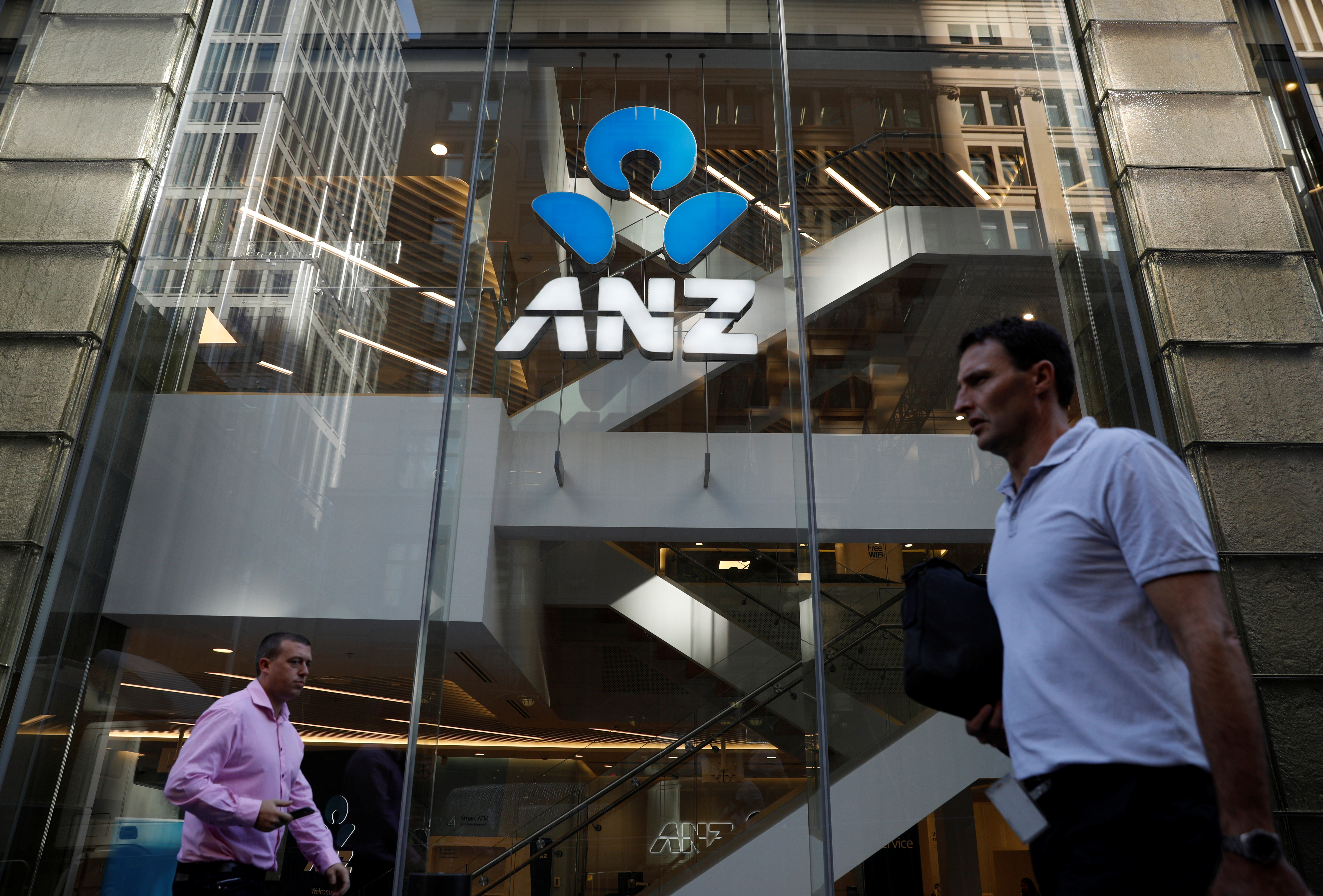 Commuters walk past an ANZ bank branch in Sydney