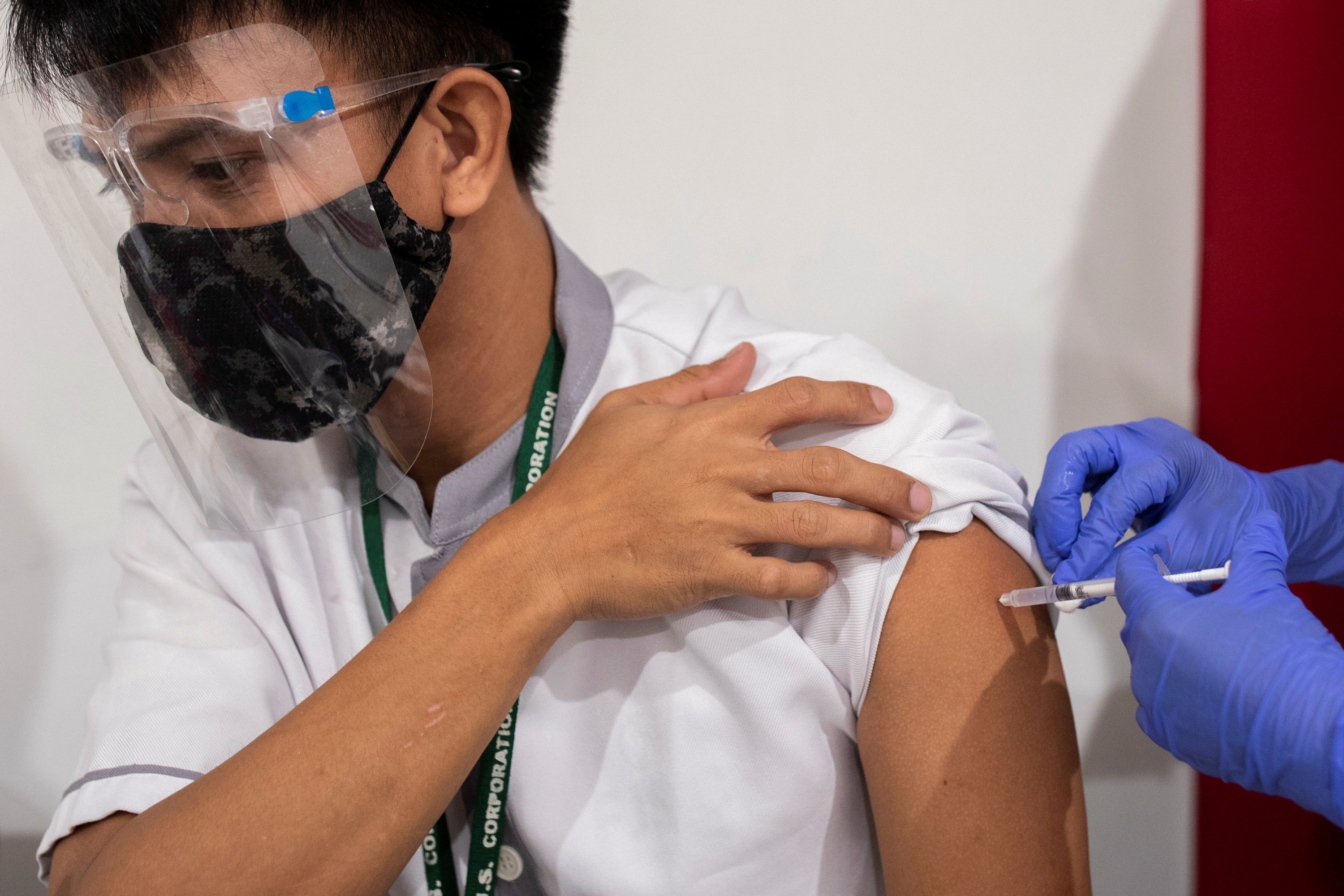 Frederick Obedoza Jr, janitor at a shopping mall, receives a dose of the Russian Sputnik V COVID-19 vaccine as vaccinations start for economic workers, at Robinsons Place, in Manila, Philippines, June 8, 2021. REUTERS/Eloisa Lopez/File Photo