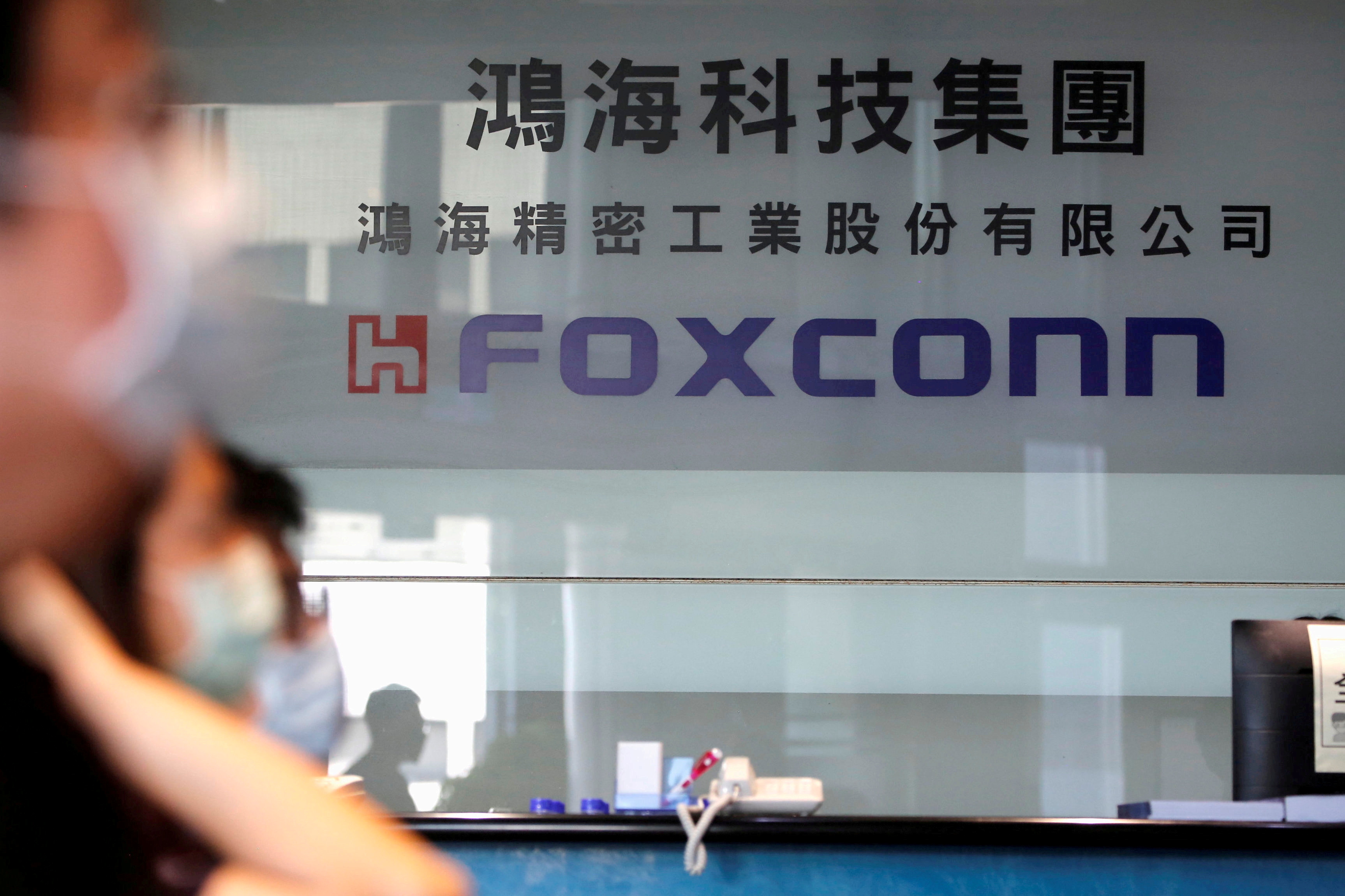 People listen to the annual general meeting at the lobby of Foxconn's office in Taipei