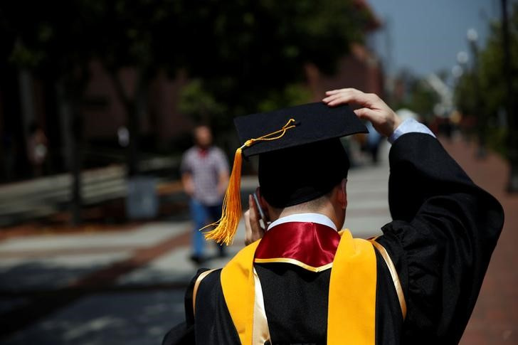 A graduate holds their mortarboard cap after a commencement ceremony at the University of Southern California (USC) in Los Angeles, California
