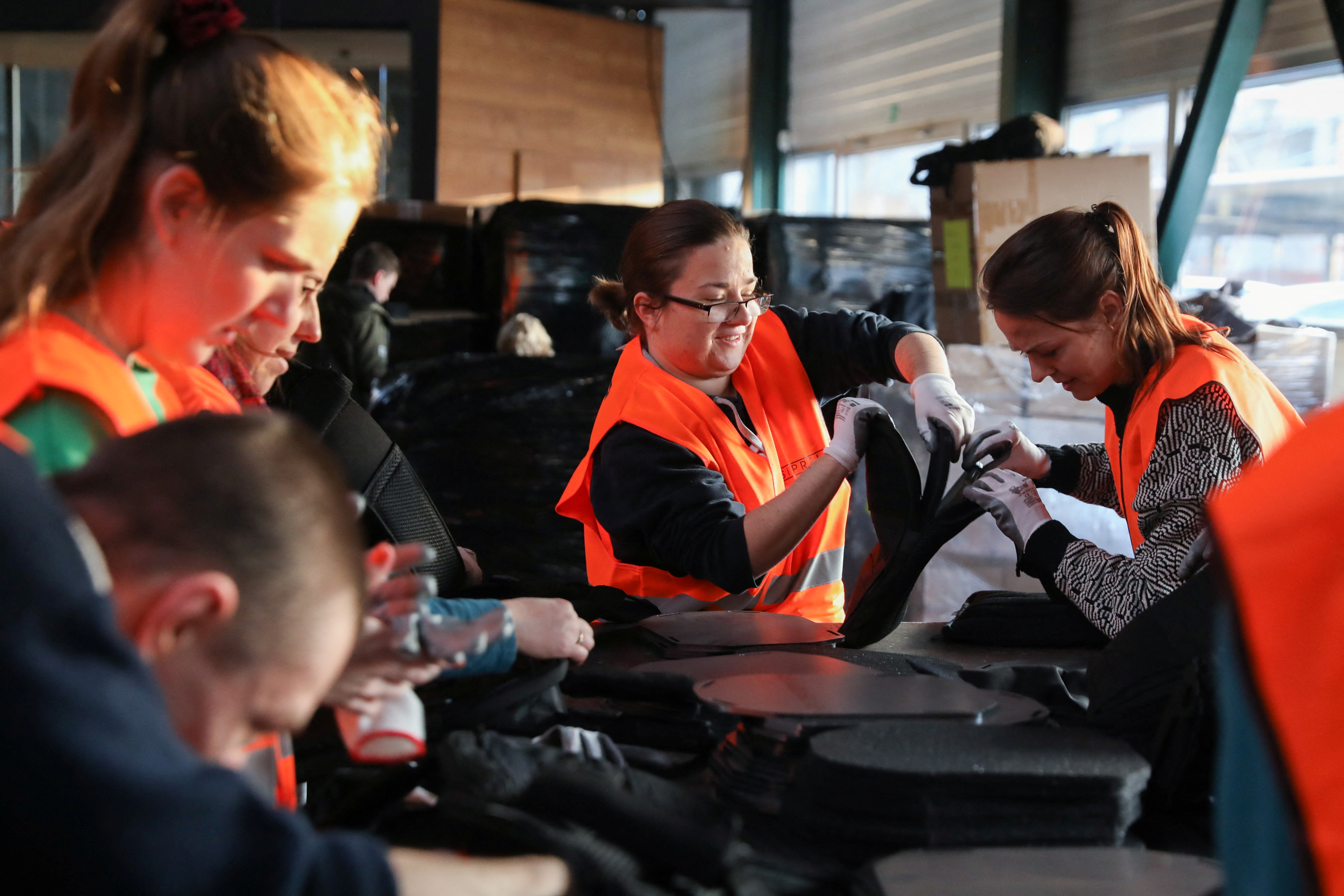 Volunteers assemble flak jackets in a warehouse in Prague