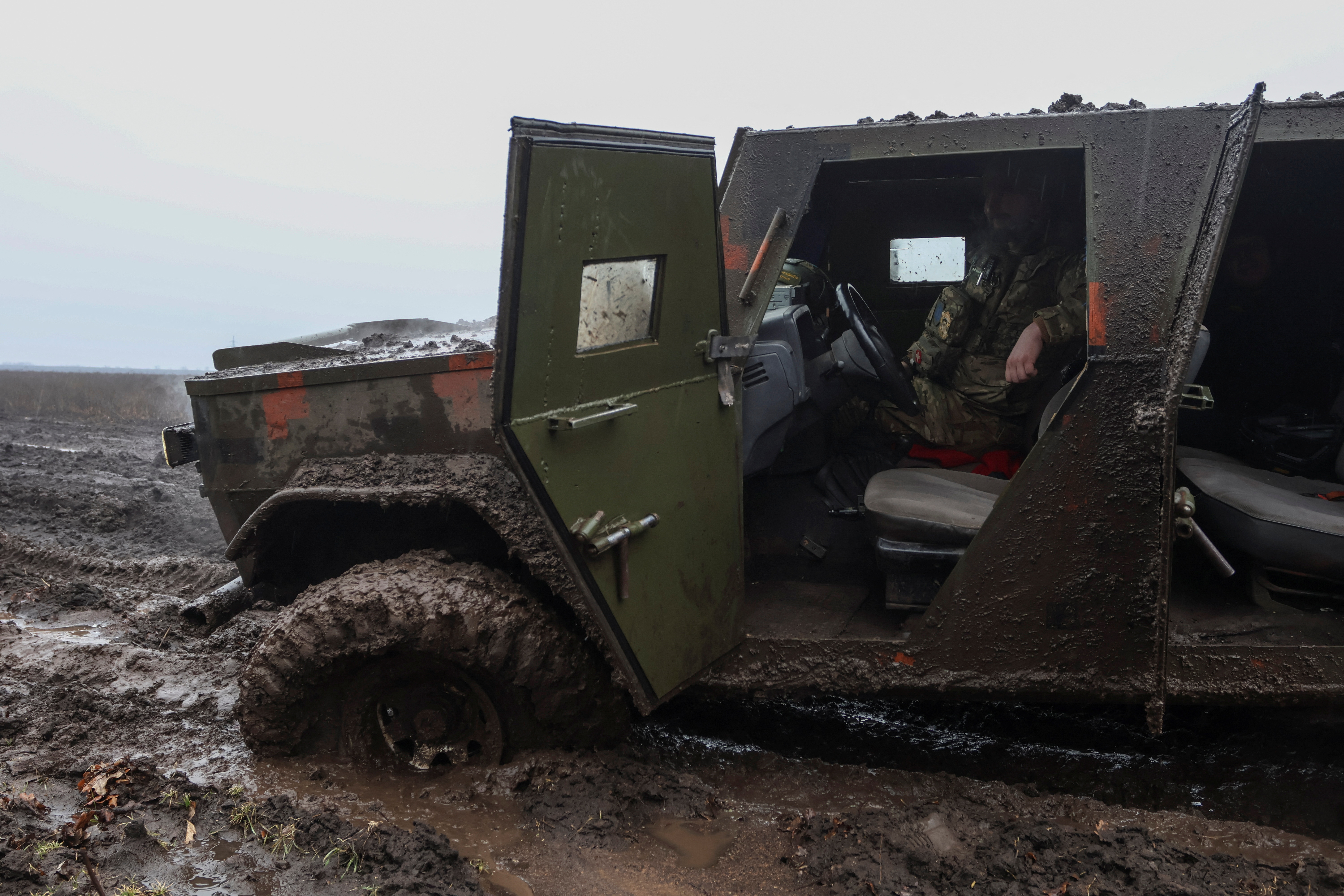 A Ukrainian service member sits inside an armoured vehicle stuck near the frontline town of Bakhmut