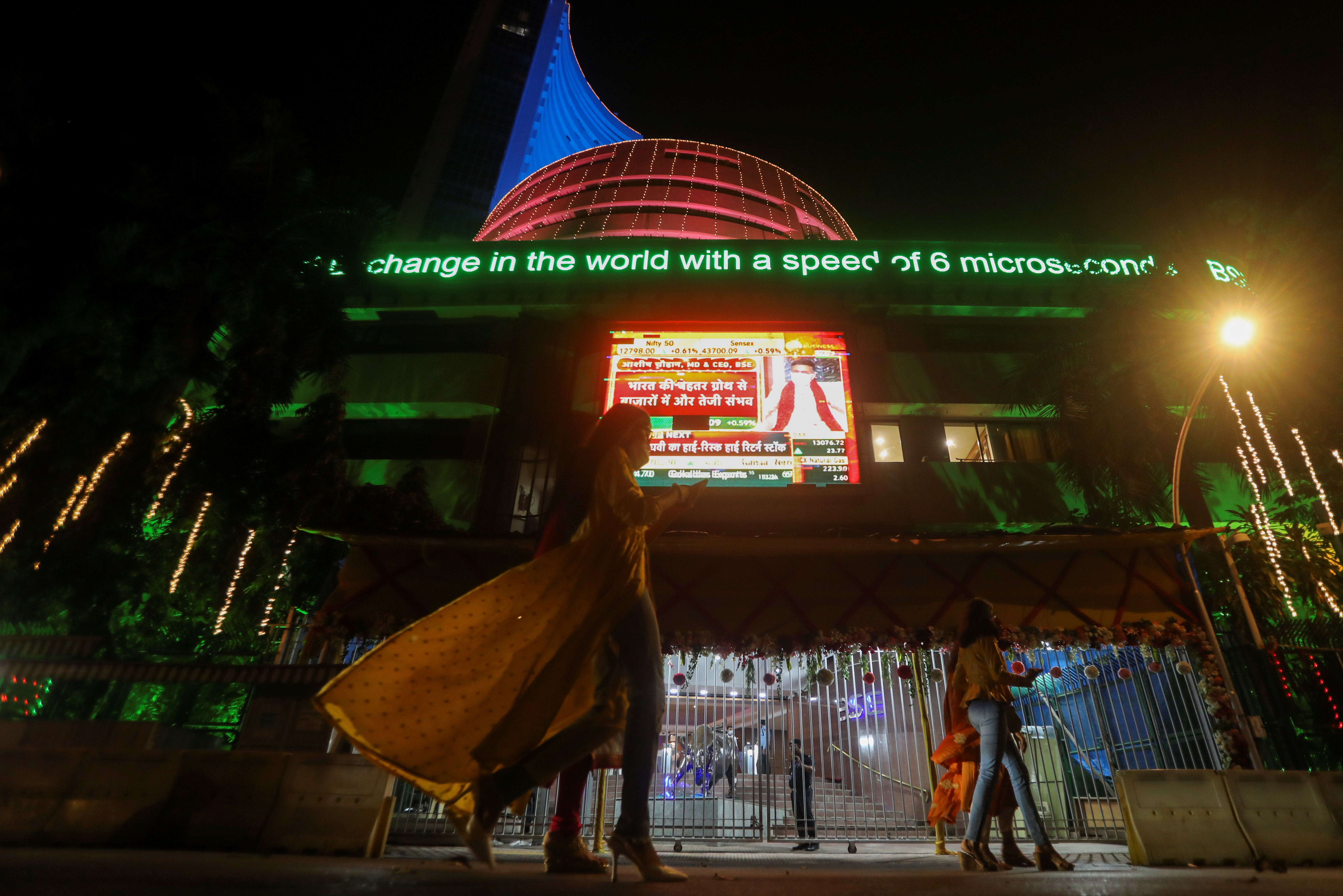 People walk past the Bombay Stock Exchange (BSE) building which was lit up during Diwali, the Hindu festival of lights, in Mumbai