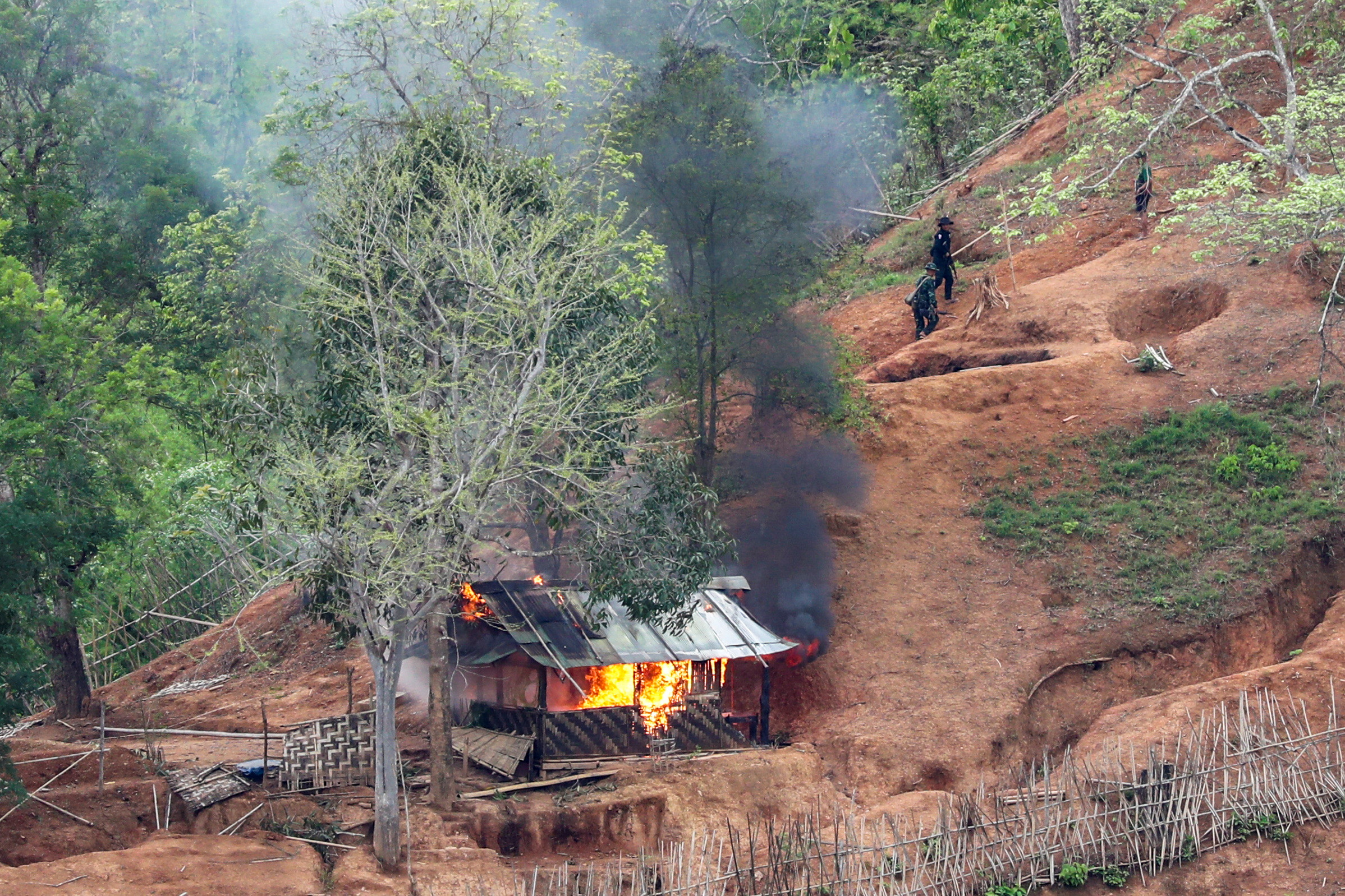 Ethnic minority Karen troops are seen after setting fire to a building inside a Myanmar army outpost near the Thai border, which is seen from the Thai side on the Thanlwin, also known as Salween, riverbank in Mae Hong Son province, Thailand, April 28, 2021. REUTERS/Athit Perawongmetha     TPX IMAGES OF THE DAY