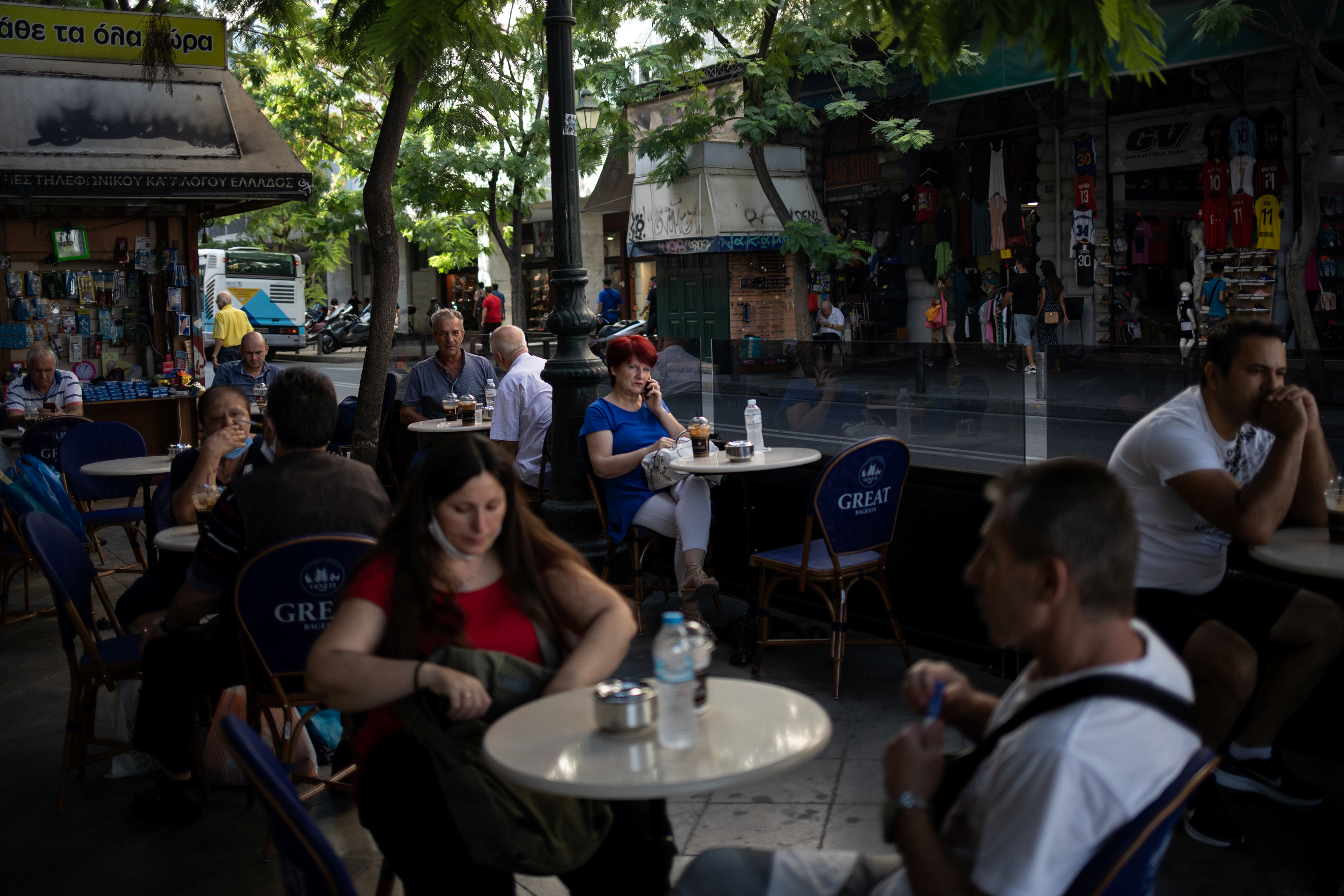 People sit in a cafe in central Athens