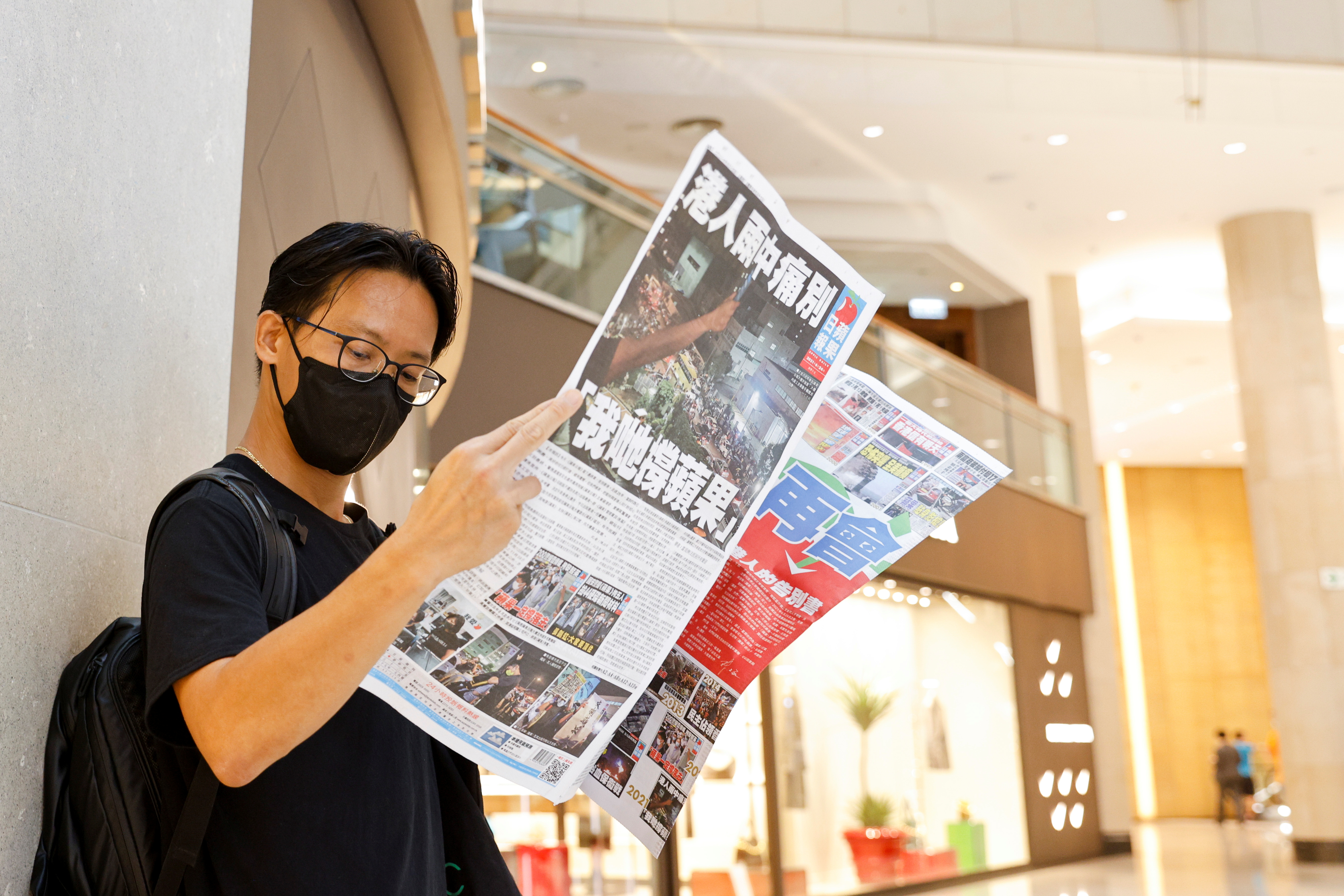 An Apple Daily supporter reads the final edition of the newspaper at a shopping mall in Hong Kong