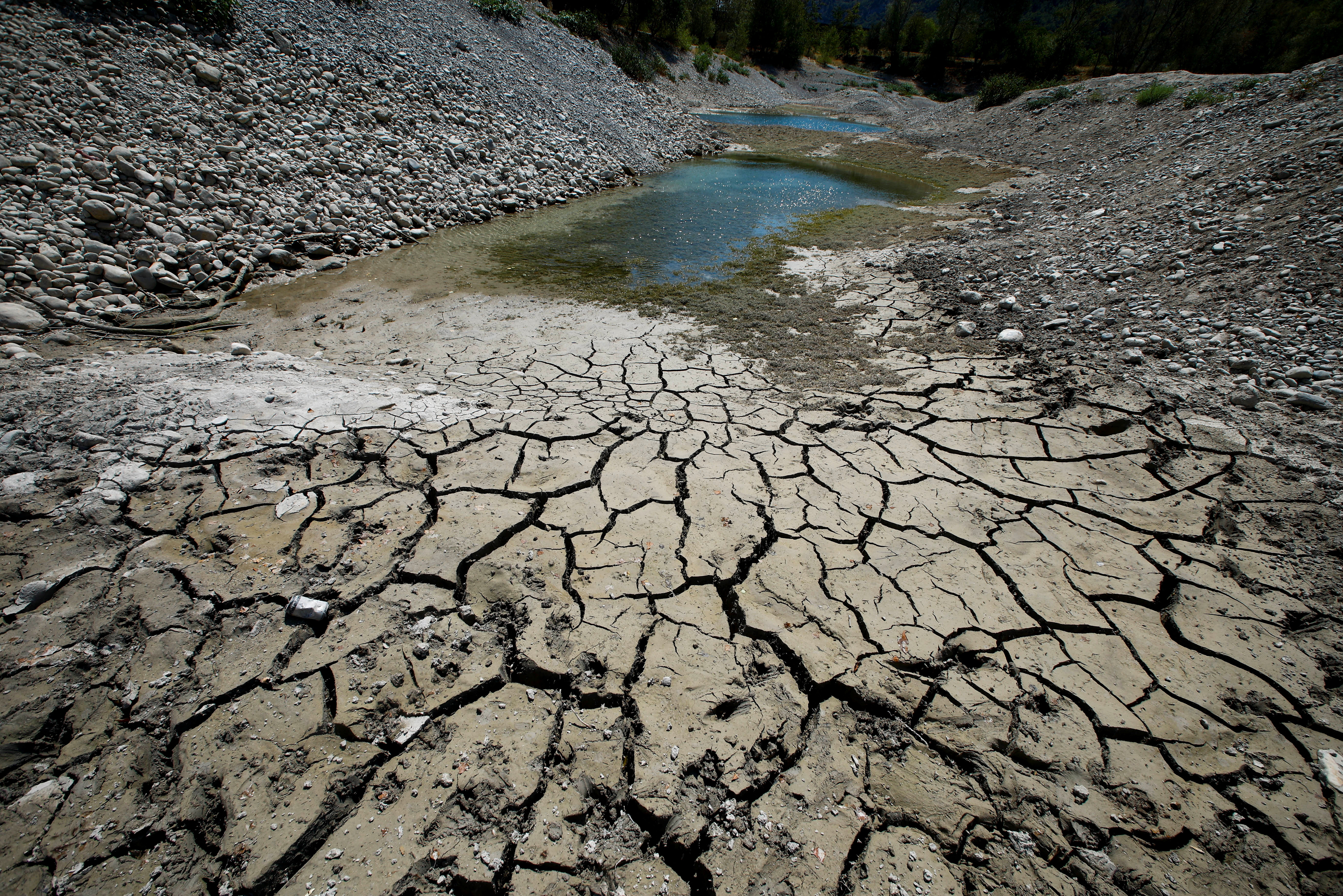 Cracked and dry earth is seen on the banks of Le Broc lake
