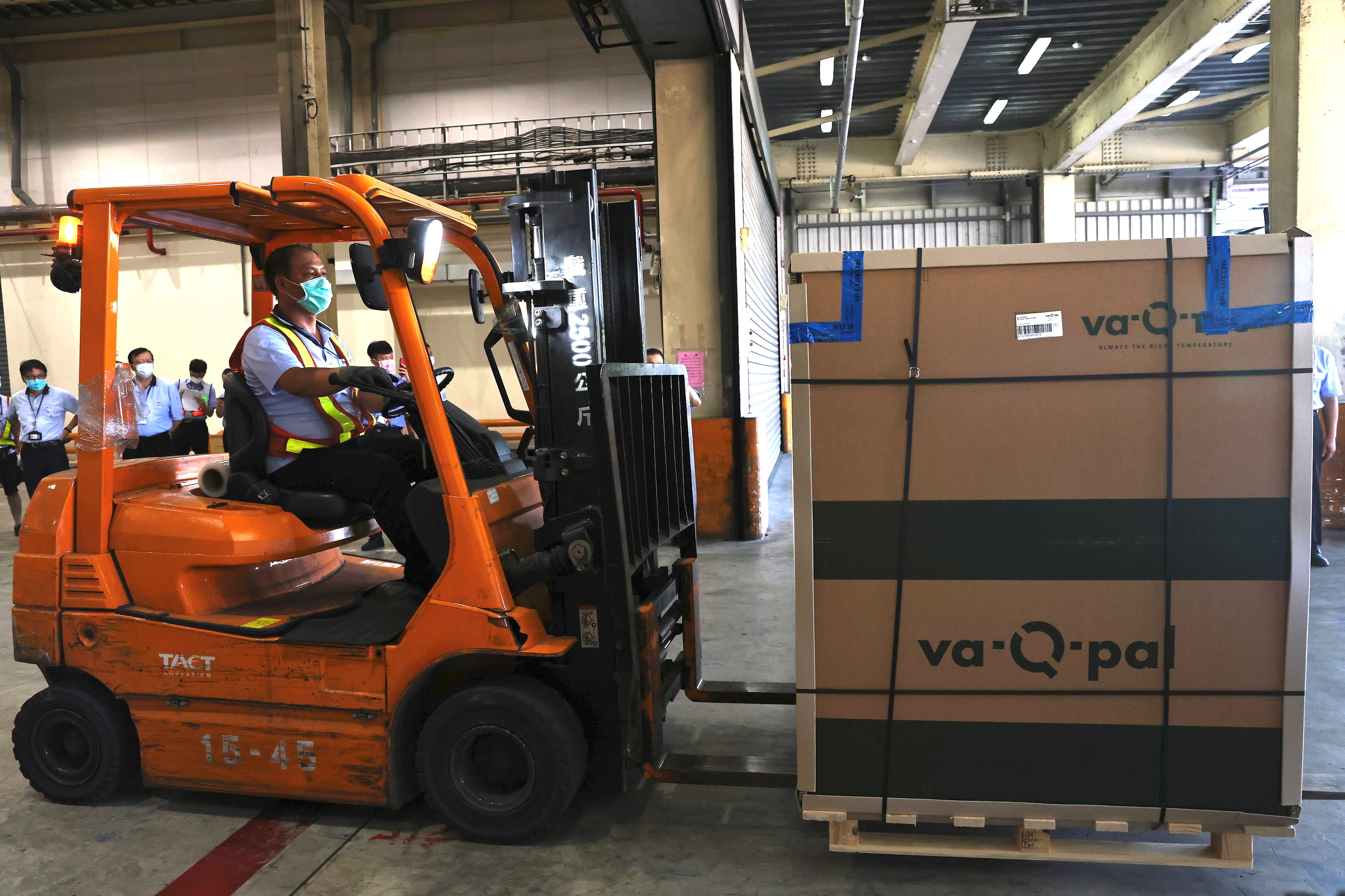 A worker operates a forklift to transport Moderna vaccines against the coronavirus disease