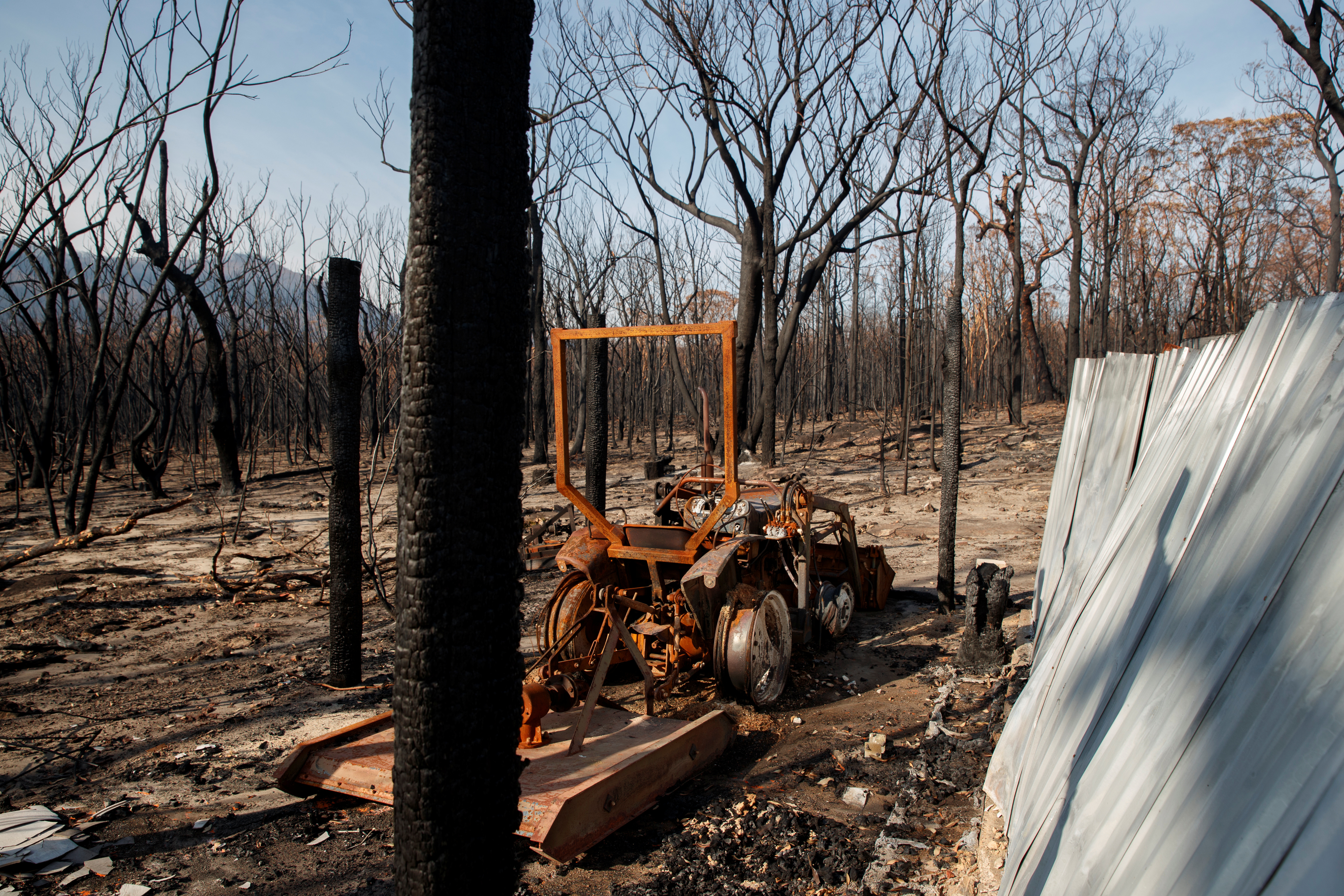 A burned tractor stands amid dead trees after a wildfire destroyed the Kangaroo Valley Bush Retreat in Kangaroo Valley