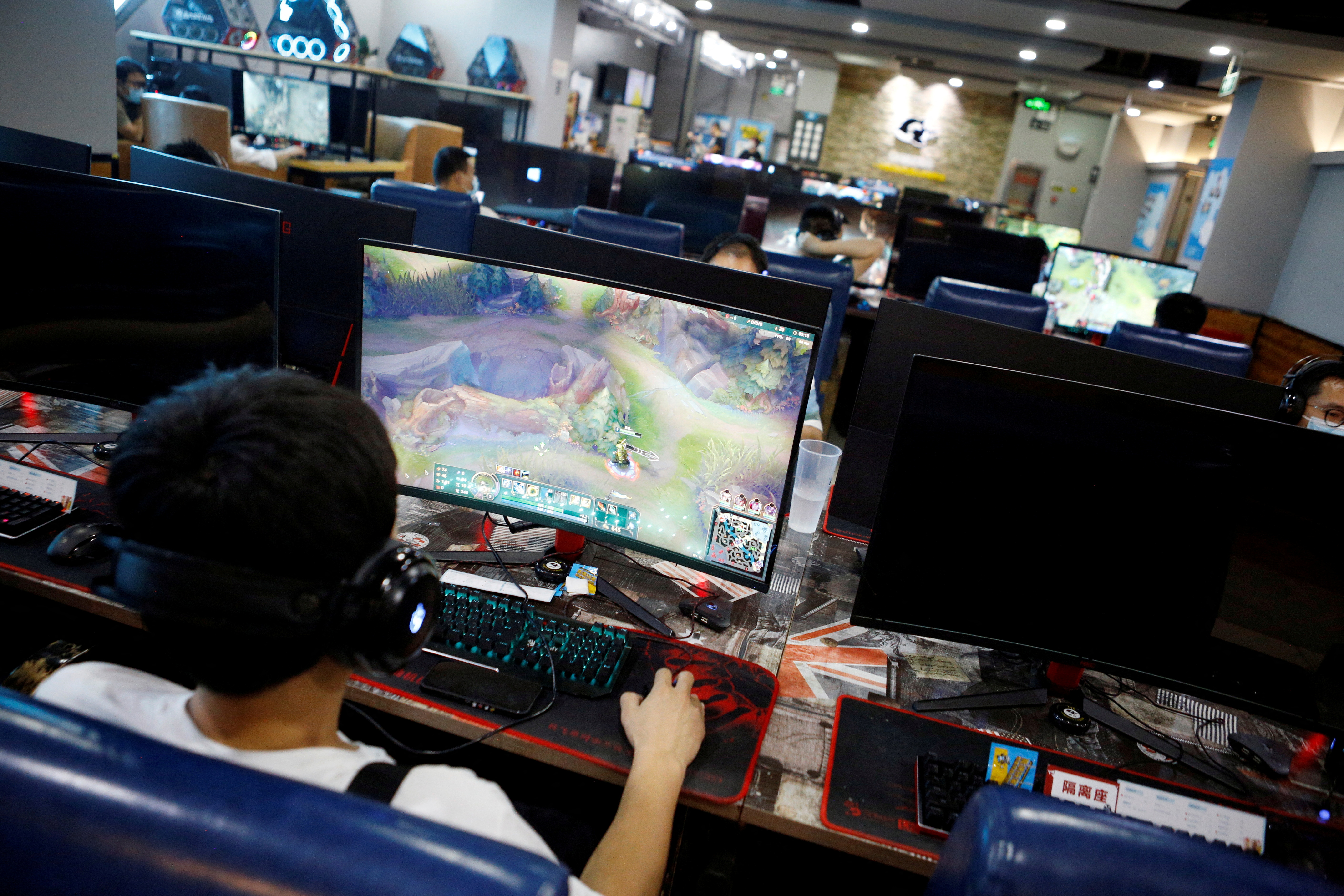 FILE PHOTO: People play online games on computers at an internet cafe in Beijing