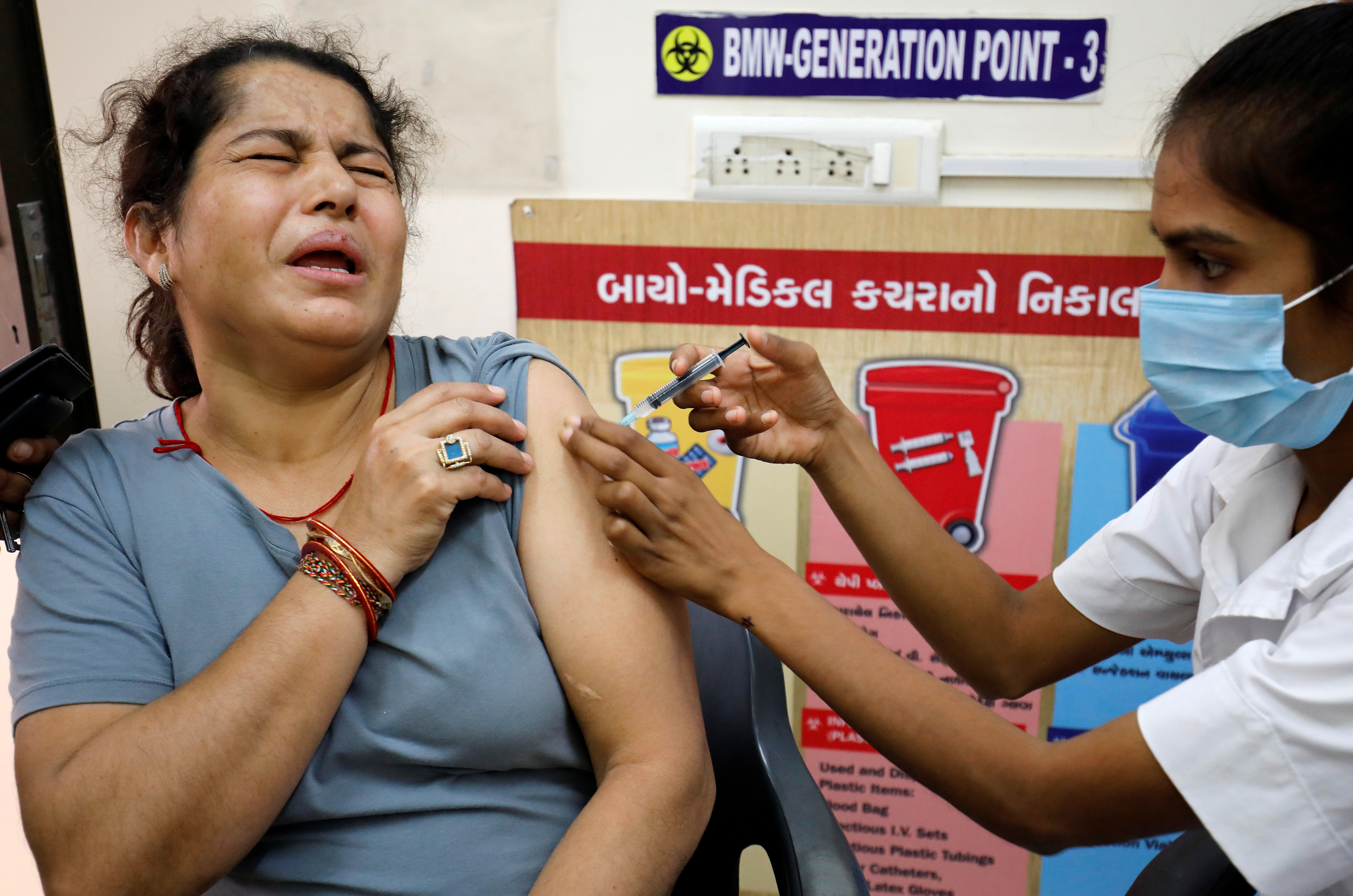 A woman reacts as she receives a dose of the COVISHIELD vaccine against the coronavirus disease (COVID-19), manufactured by Serum Institute of India, at a vaccination centre in Ahmedabad, India, October 21, 2021. REUTERS/Amit Dave