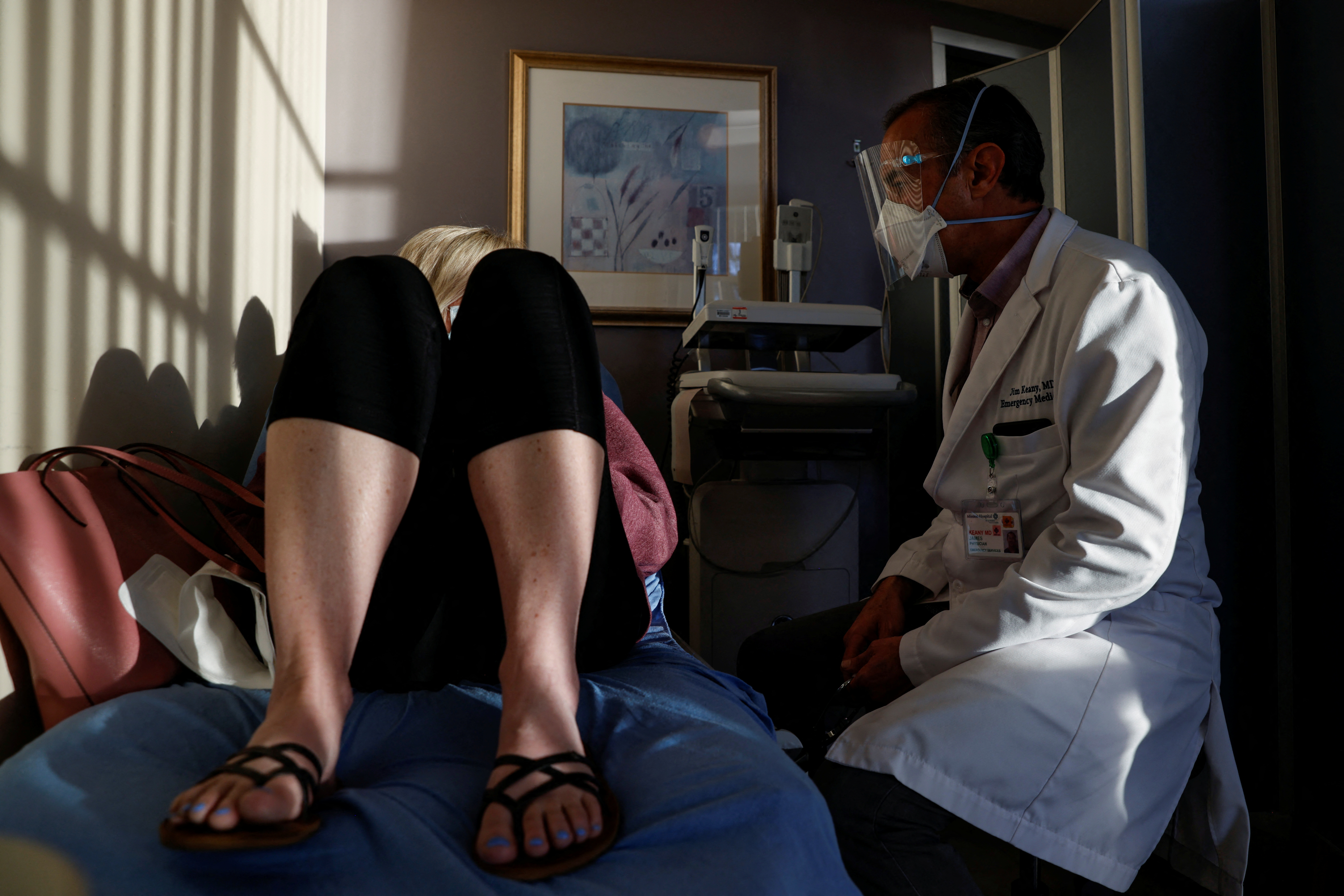 Emergency room doctor Jim Keany treats a coronavirus patient in a respiratory isolation room. REUTERS/Shannon Stapleton