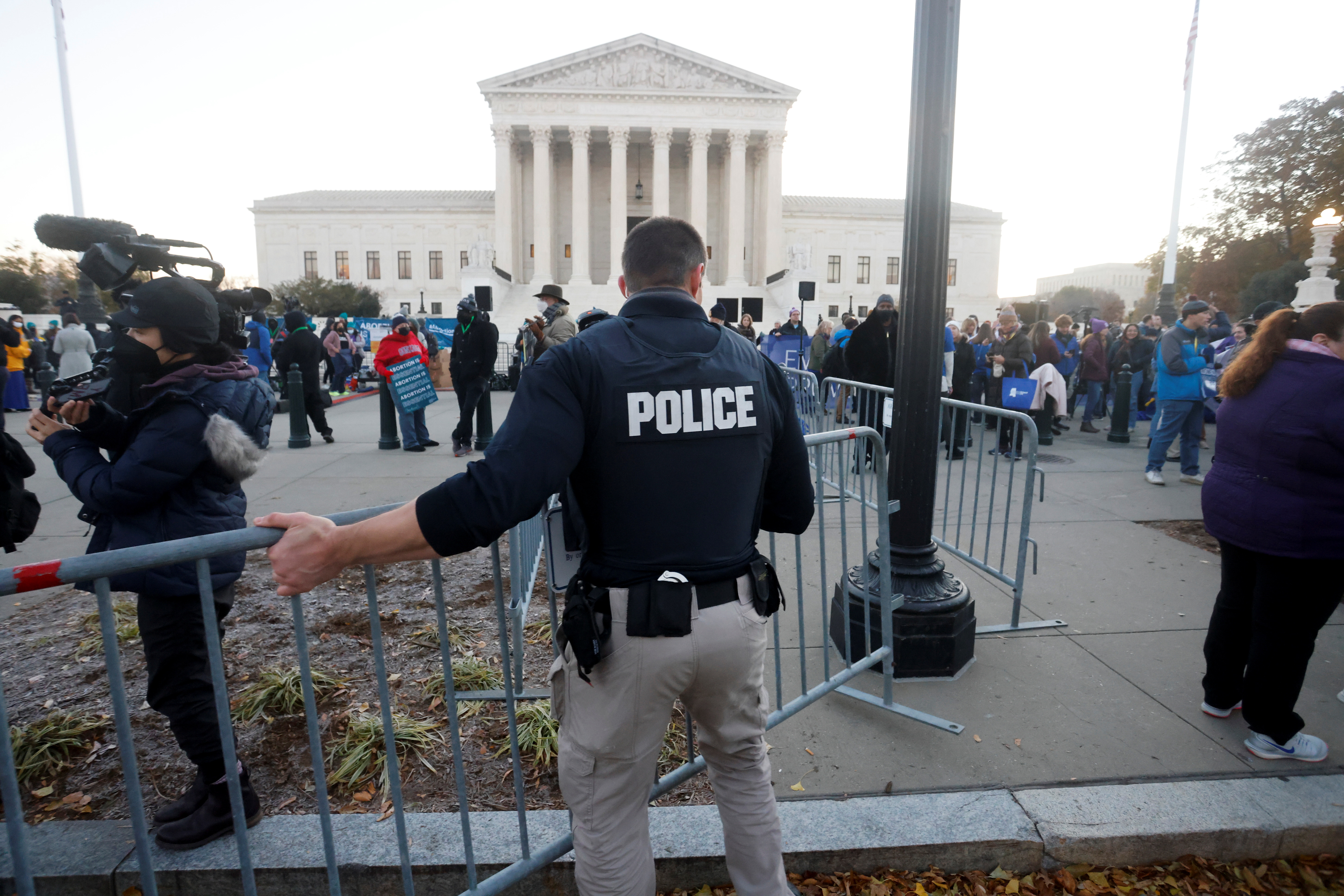 A Supreme Court Police officer erects a barrier between anti-abortion and pro-abortion rights protesters outside the court building, ahead of arguments in the Mississippi abortion rights case Dobbs v. Jackson Women's Health, in Washington, U.S., December 1, 2021. REUTERS/Jonathan Ernst