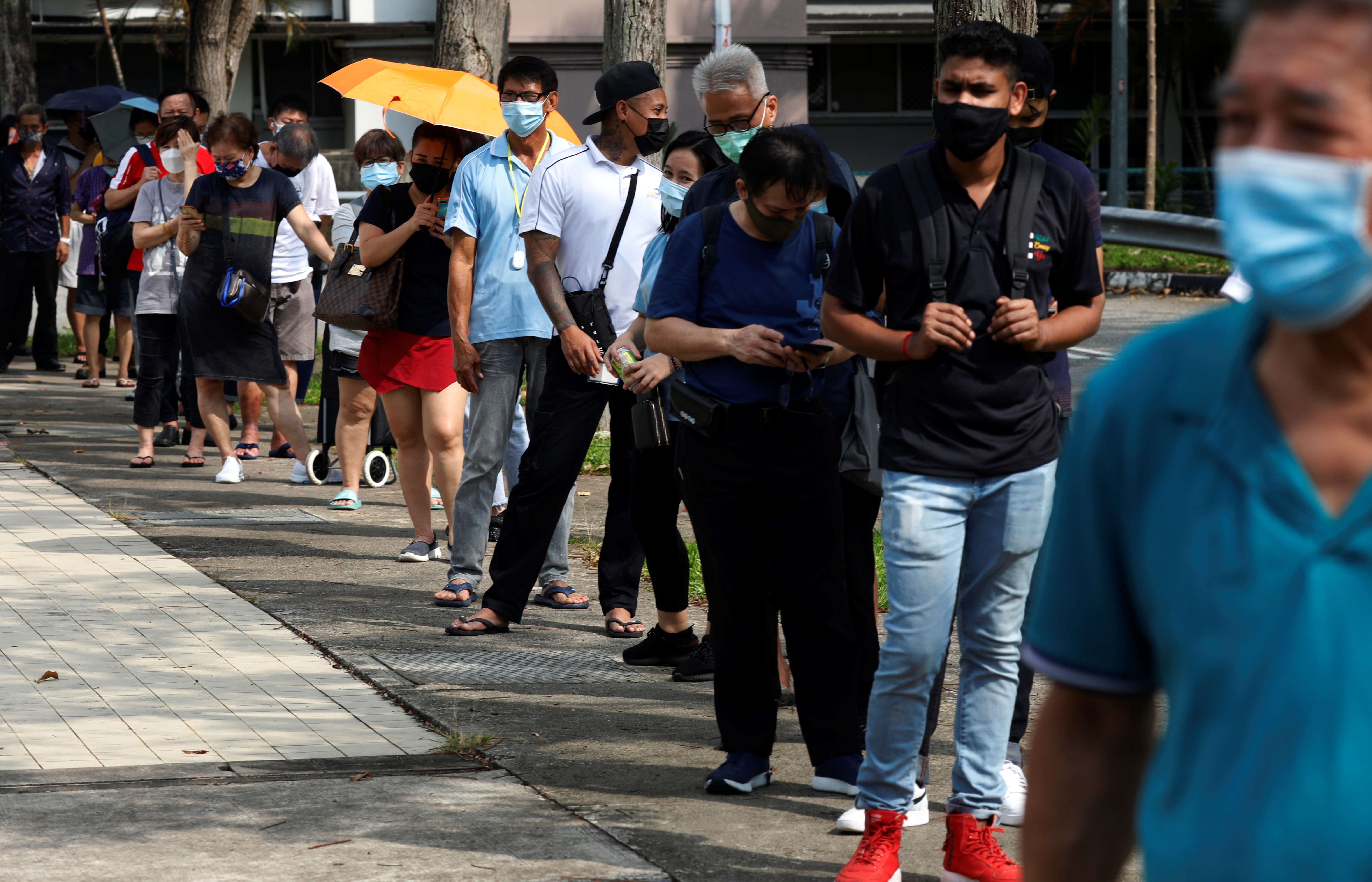 People queue up outside a quick test centre to take their coronavirus disease (COVID-19) antigen rapid tests, in Singapore September 21, 2021. REUTERS/Edgar Su