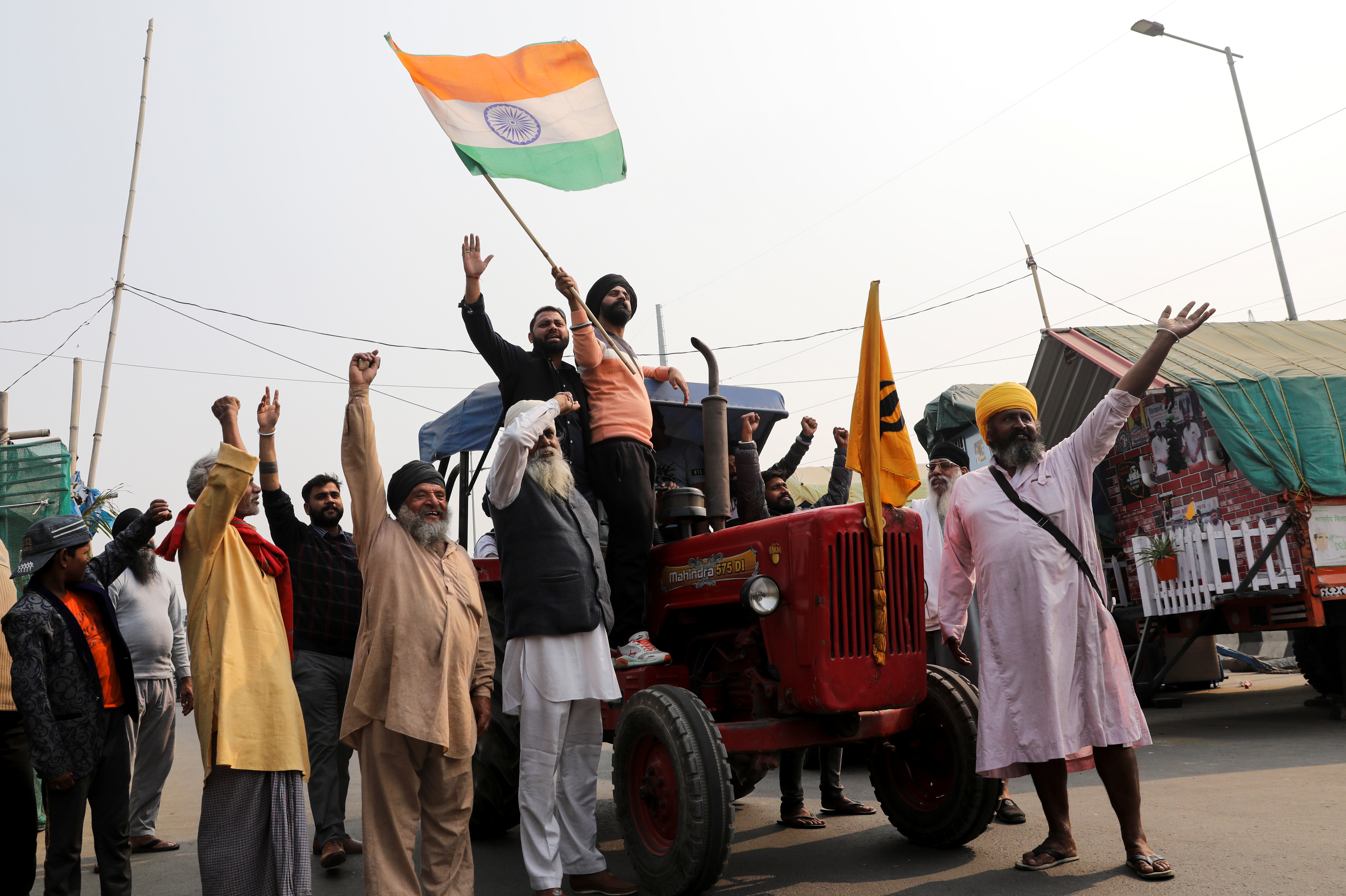 Farmers celebrate after Indian Prime Minister Narendra Modi announced that he will repeal the controversial farm laws, at the Ghazipur farmers protest site near Delhi-UP border, India, November 19, 2021. REUTERS/Anushree Fadnavis