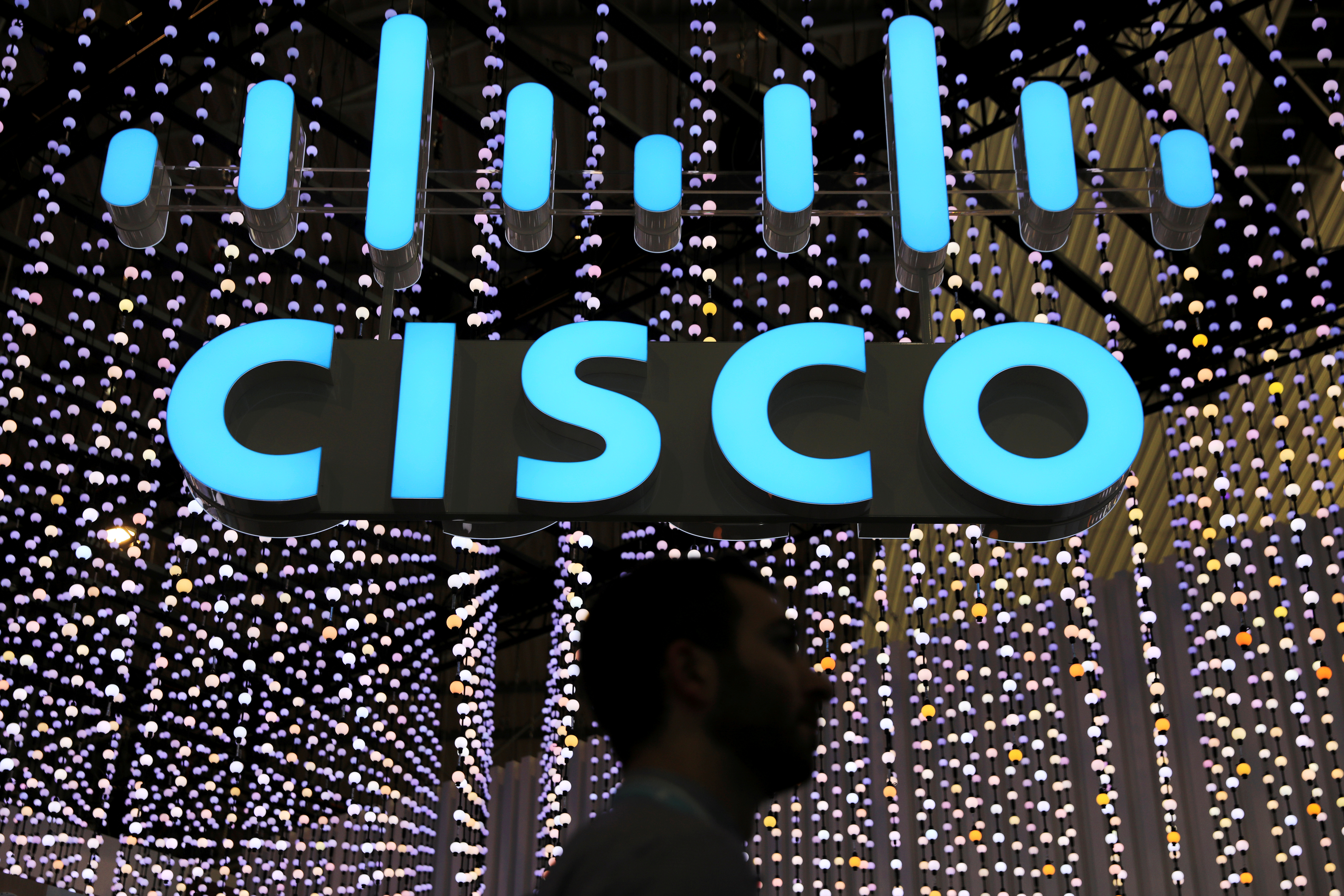 A man passes under a Cisco sign at the Mobile World Congress in Barcelona