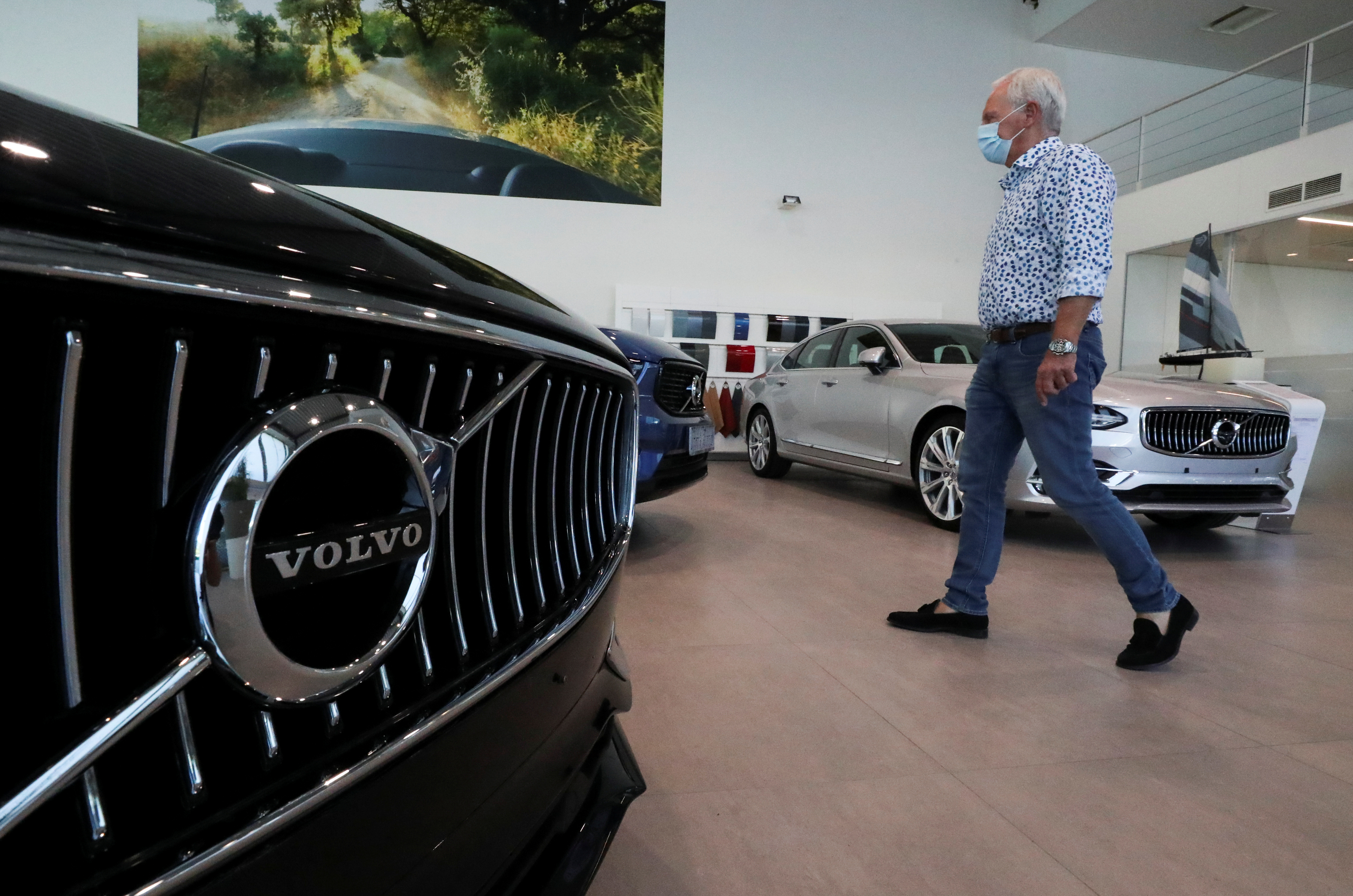 An employee at a Volvo car dealer wearing a protective mask is seen in the show room, amid the coronavirus disease (COVID-19) outbreak in Brussels