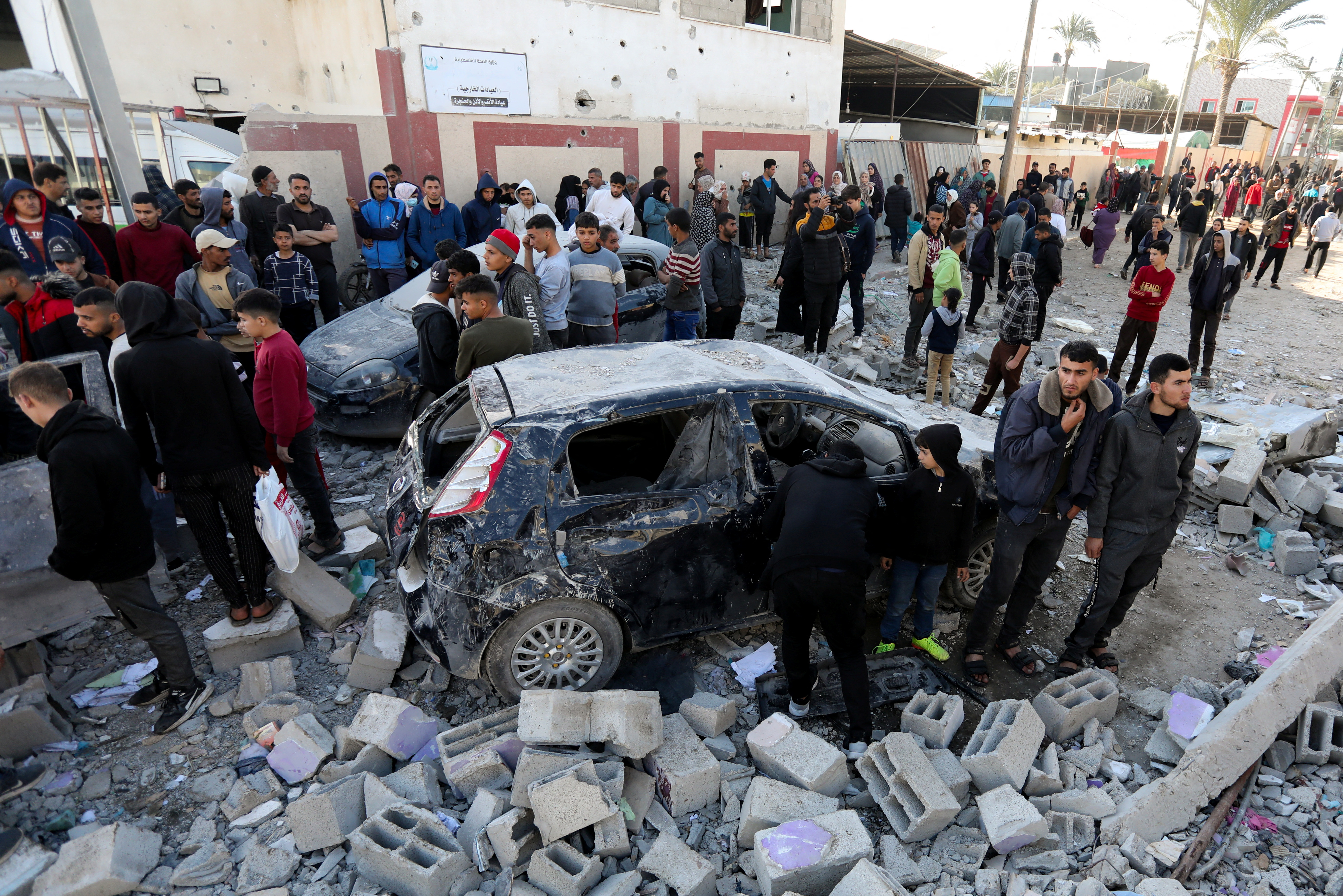 Palestinians inspect the site of an Israeli strike in Deir Al-Balah