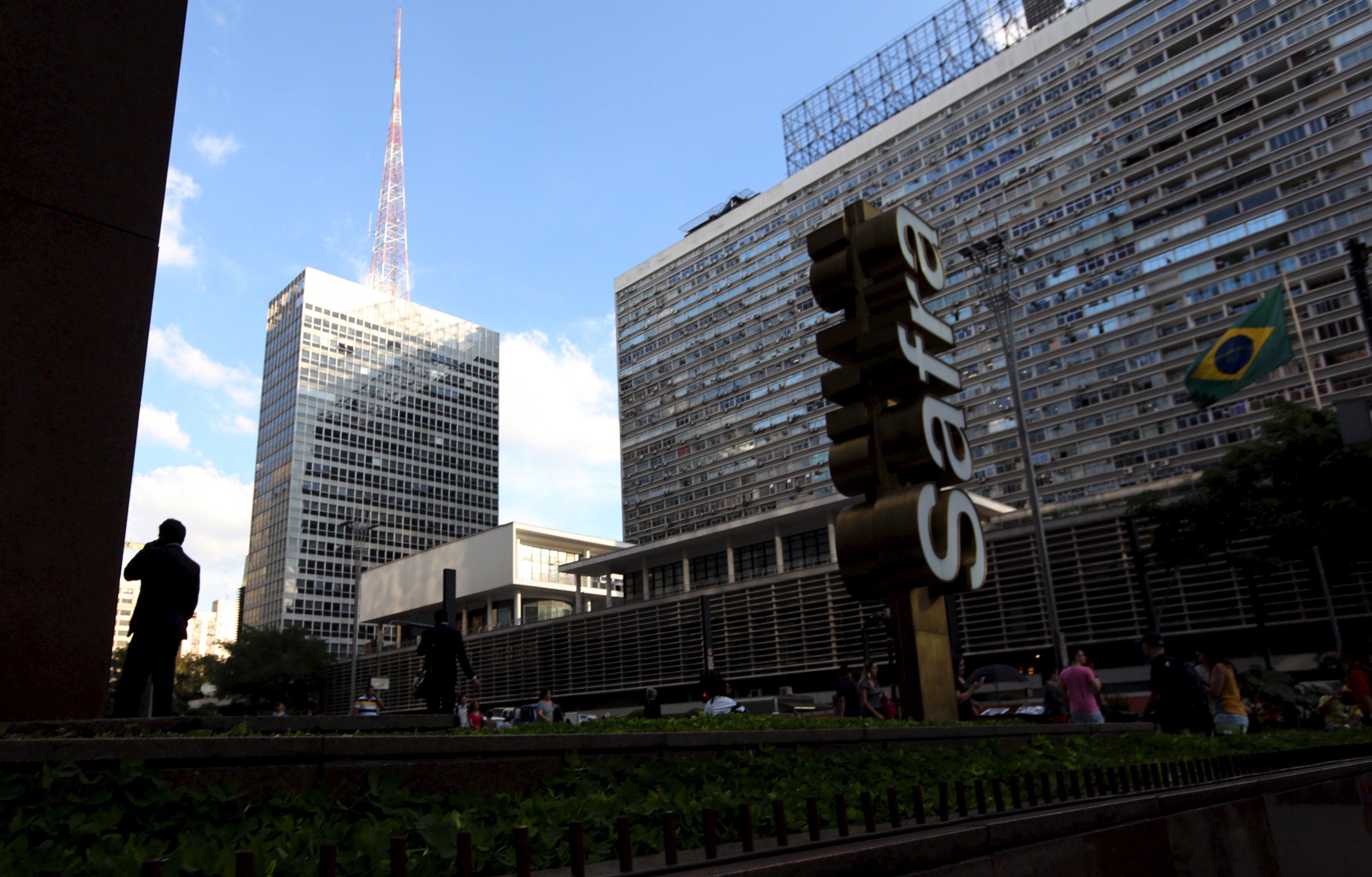 A man talks on his mobile phone next to the  Banco Safra SA headquarter in Sao Paulo