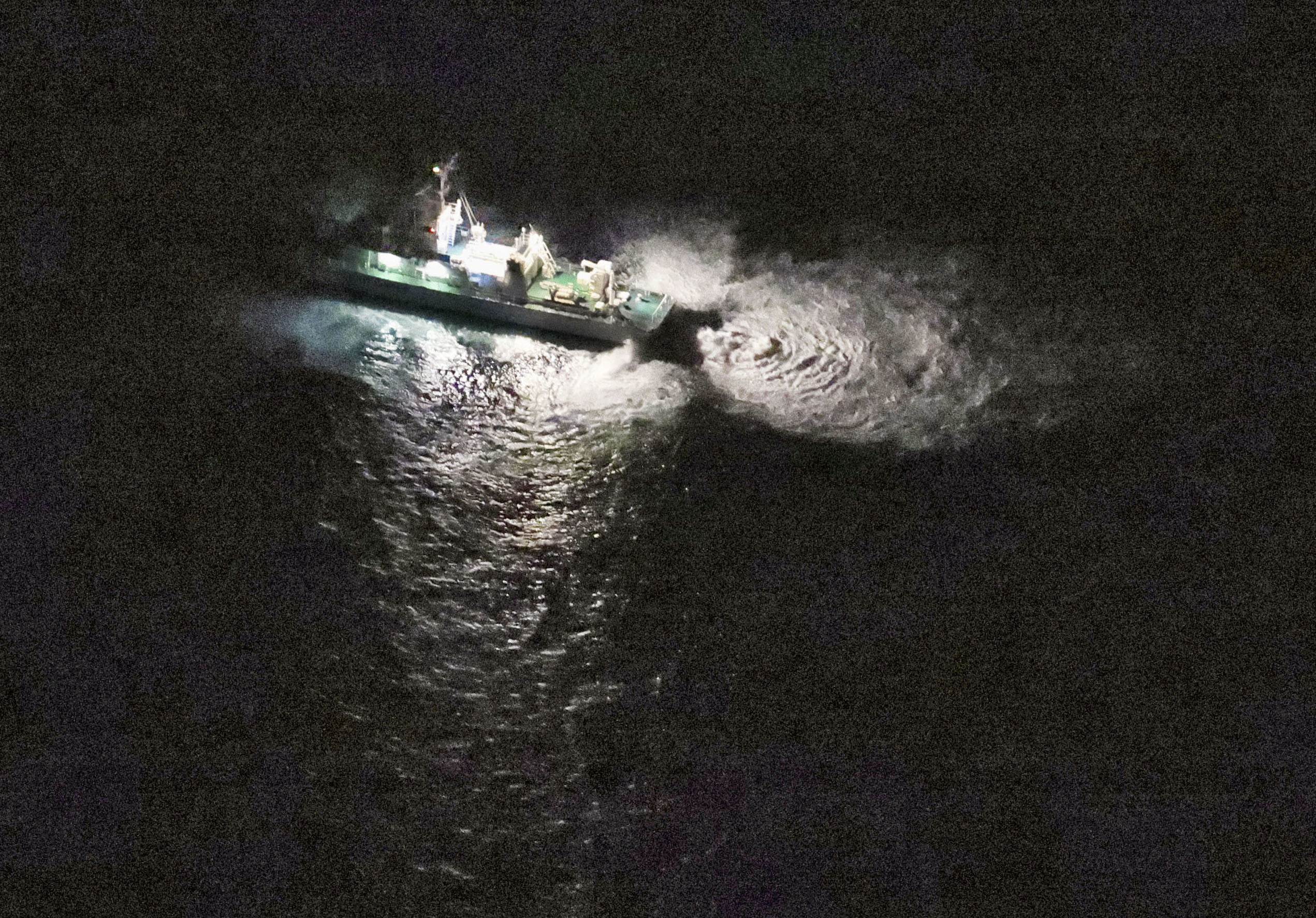 A Japan Coast Guard vessel conducts search and rescue operation at the site where a U.S. military aircraft MV-22 Osprey crashed into the sea off Yakushima Island, Japan